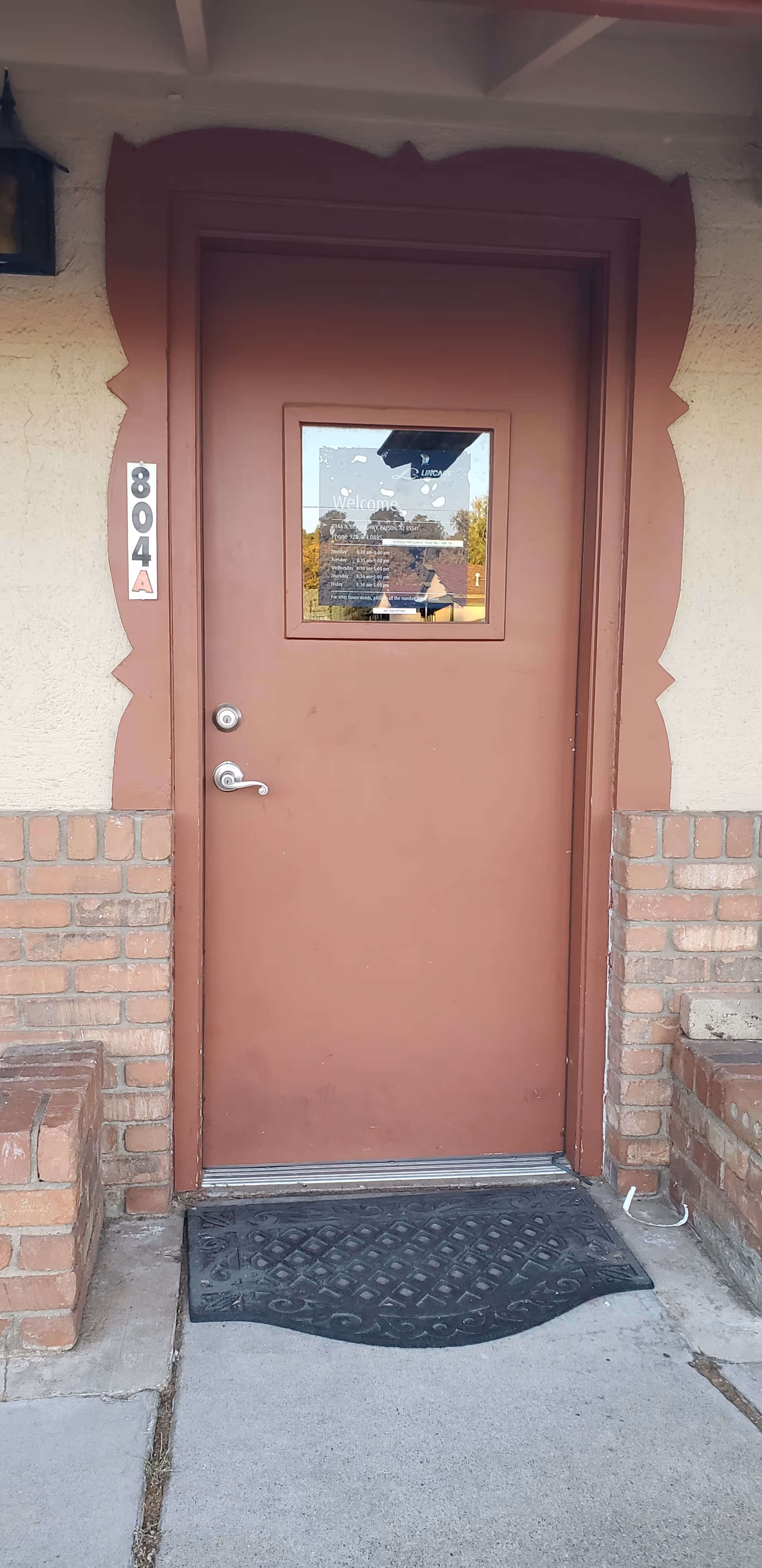 Exterior entrance door with decorative frame, brick walls, and the address 804.