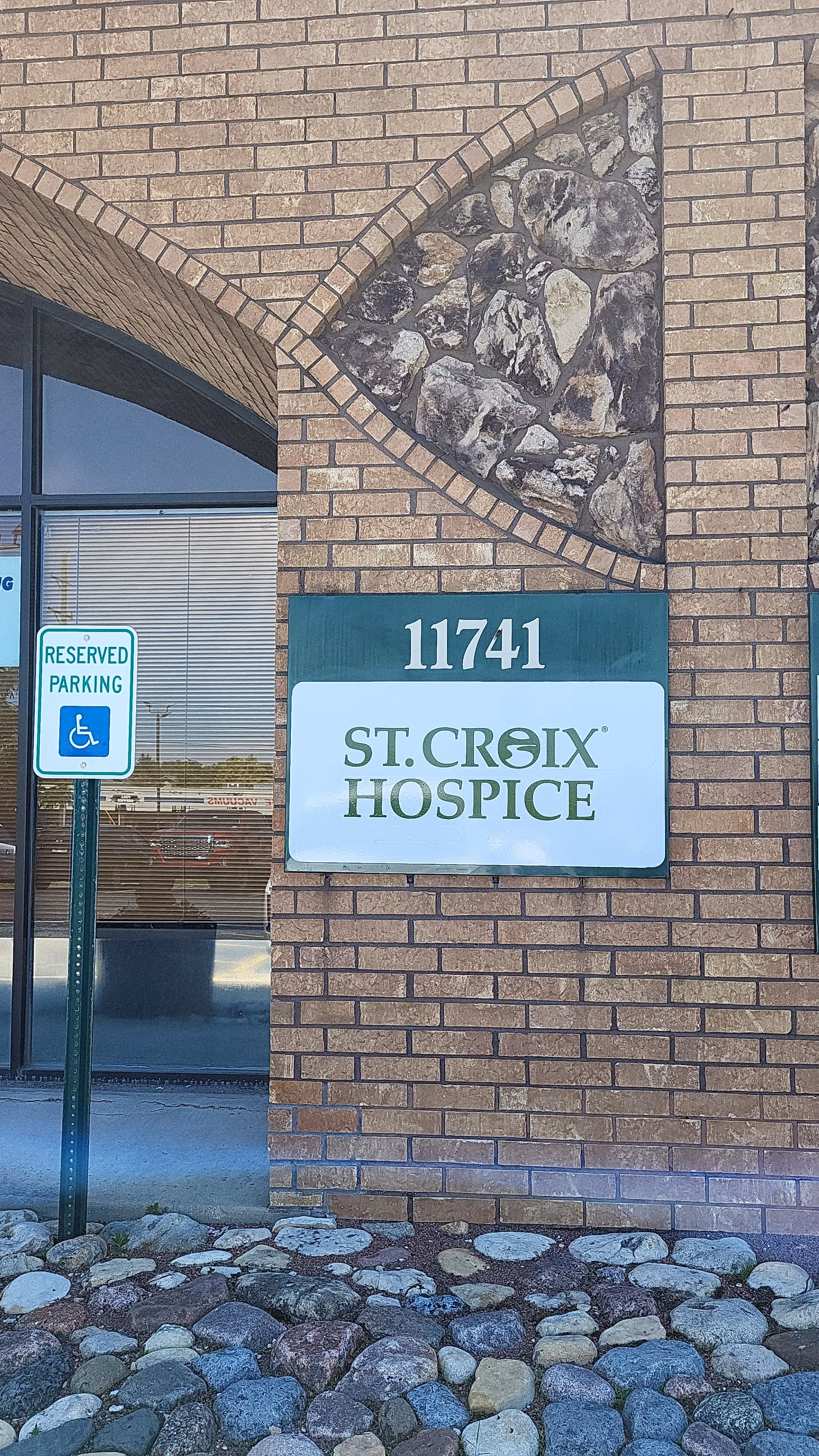 Exterior view of St. Croix Hospice building front with sign and reserved parking.