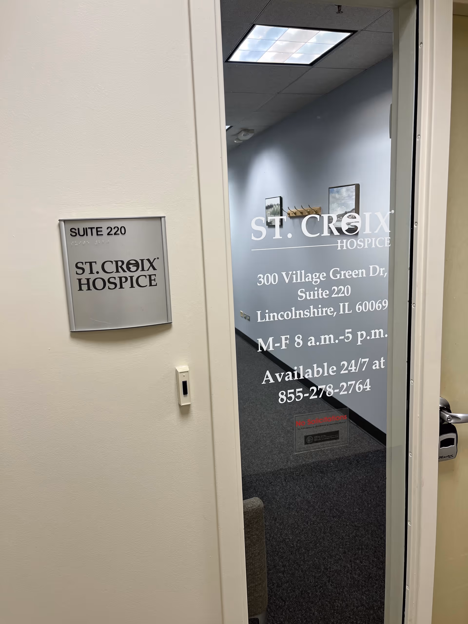 Glass door with St. Croix Hospice sign in a hallway.