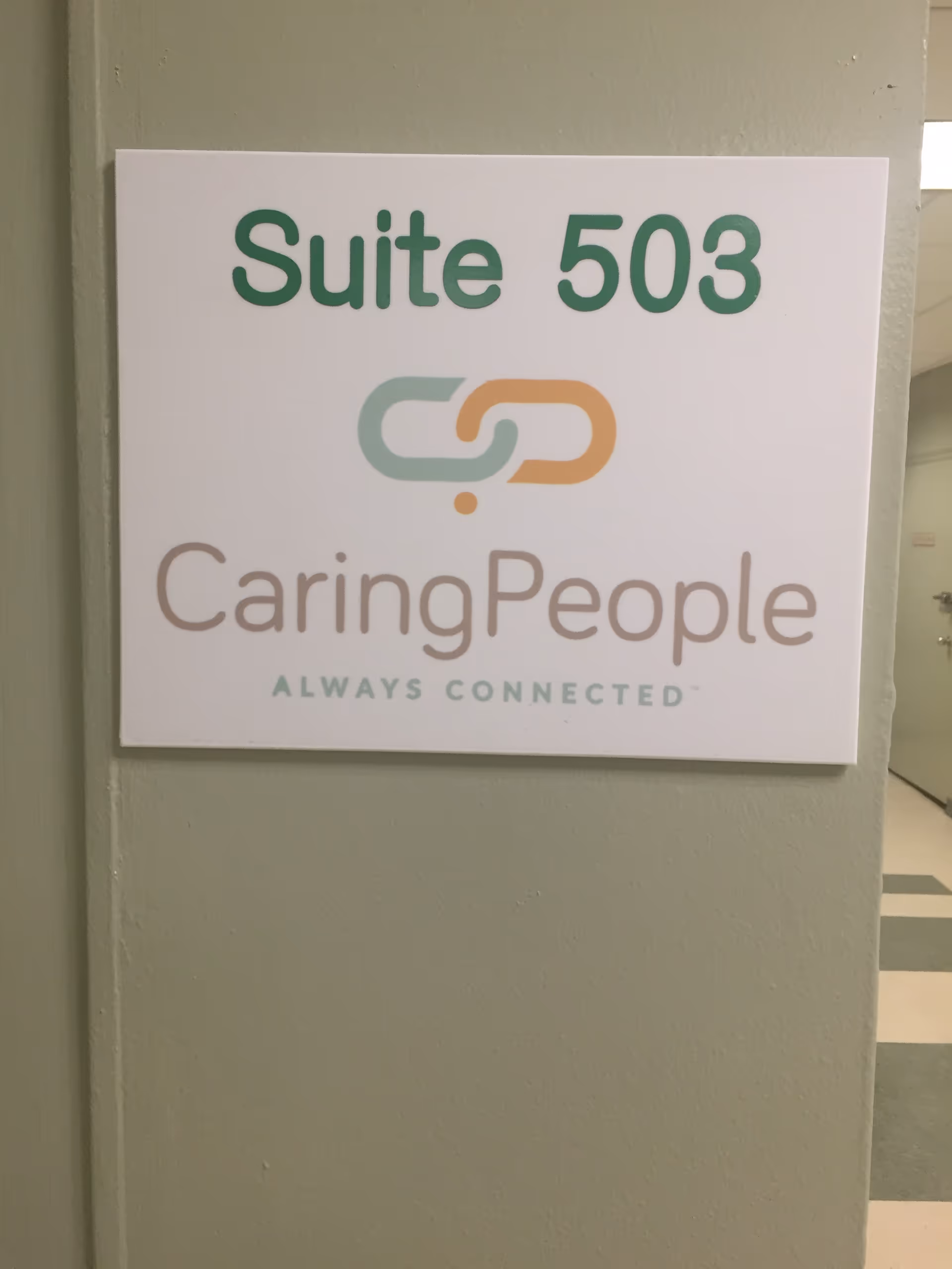 Sign on green wall showing Suite 503 and CaringPeople logo.