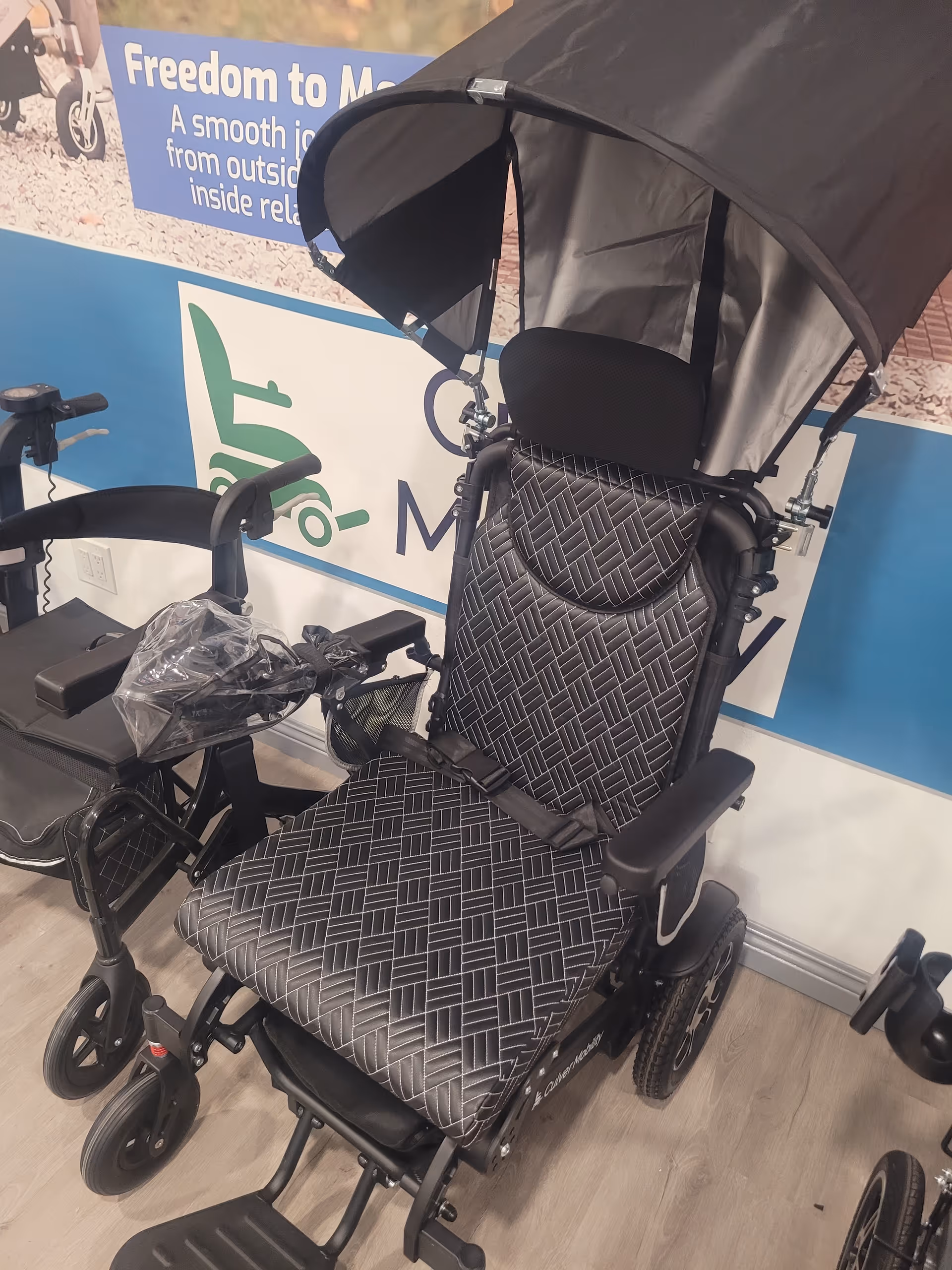 Indoor display of a motorized wheelchair with canopy at Culver Mobility.