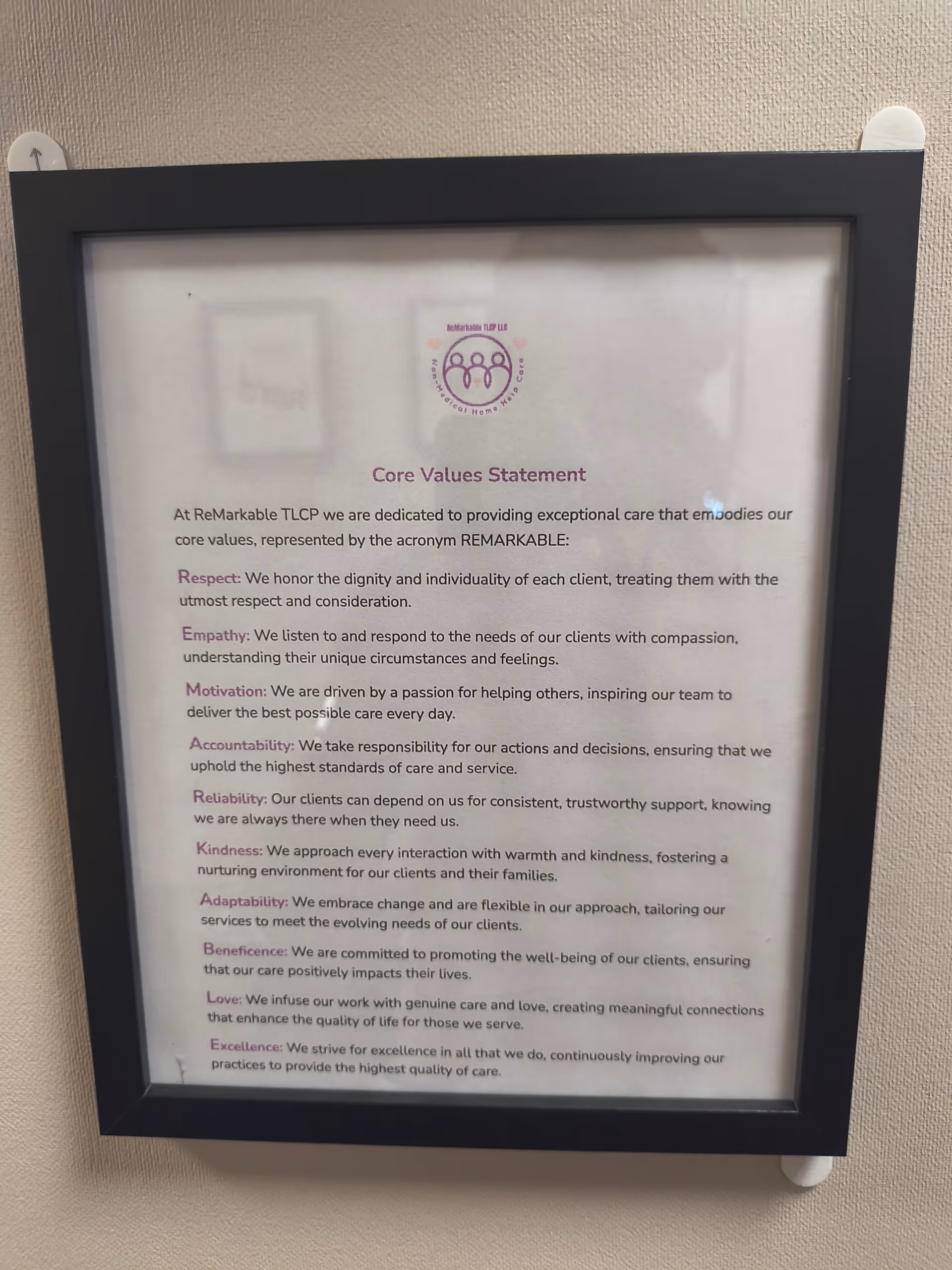 Framed Core Values Statement poster mounted on a beige interior wall.