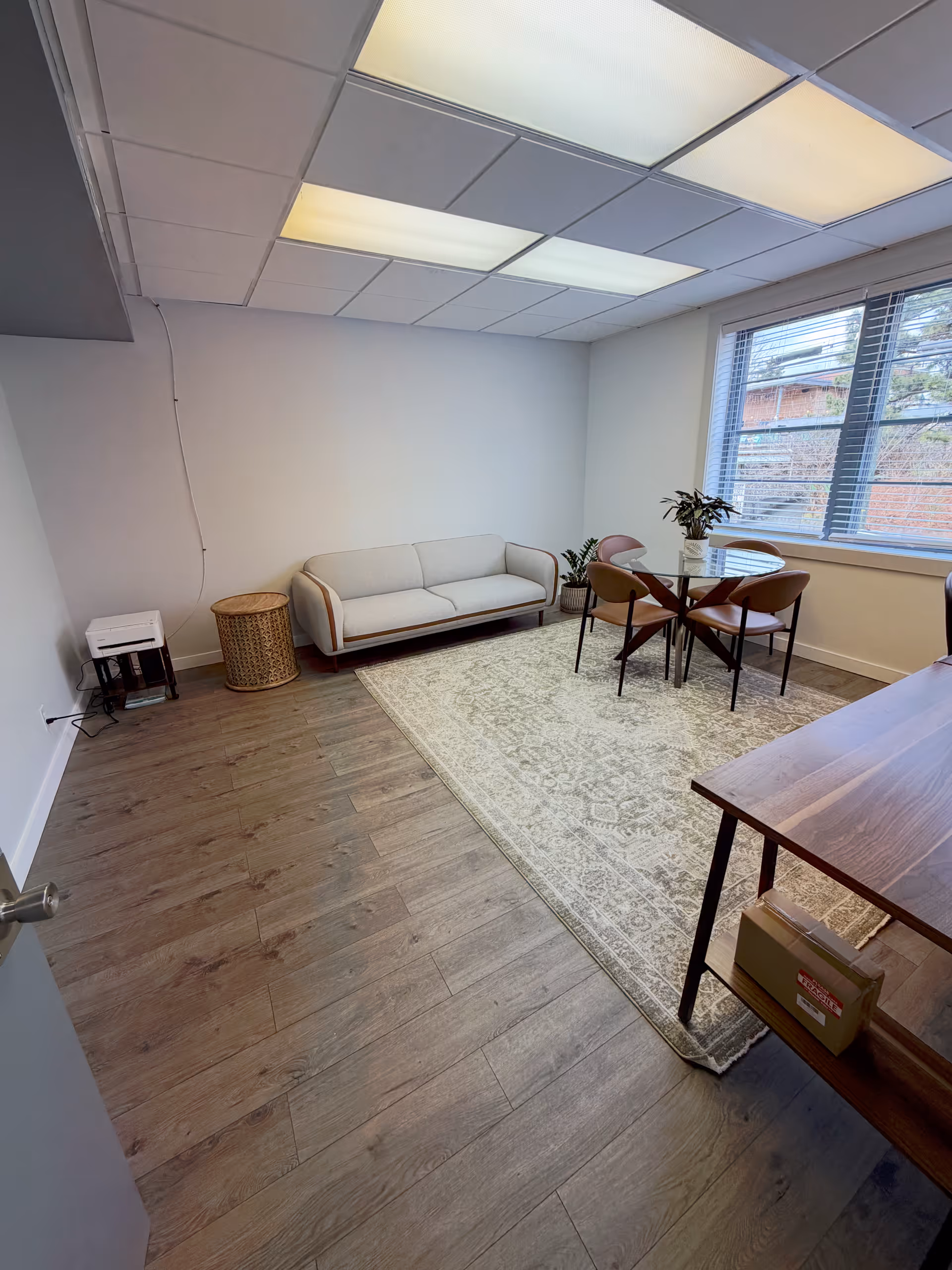 Lounge area in a dementia care facility with sofa, rug, and round table.