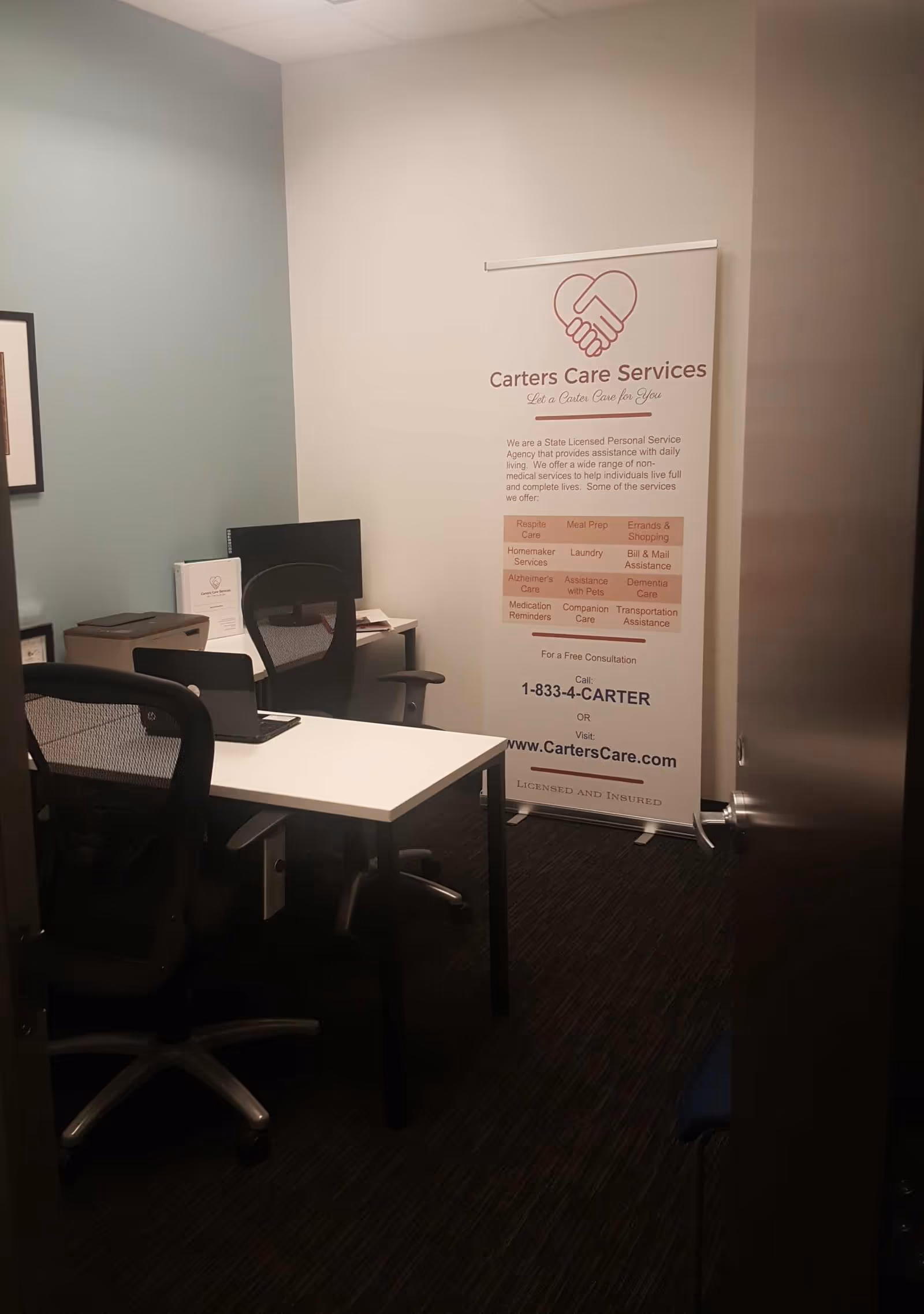 Office area with desks, chairs, and a Carters Care Services banner near the entrance.