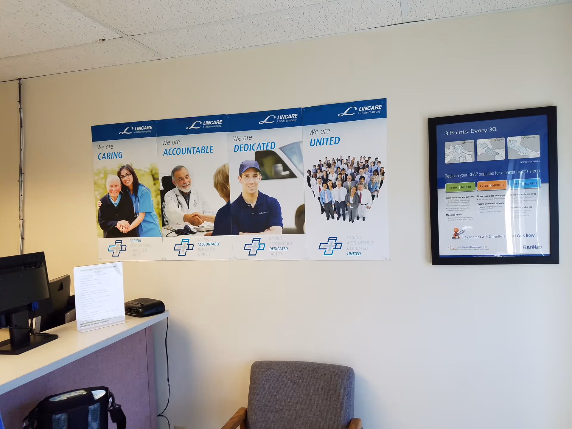 Reception area featuring LINCARE posters on the wall beside a computer desk.