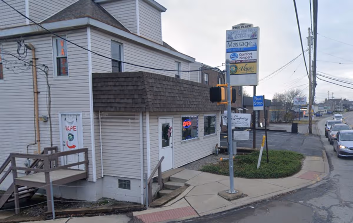 Exterior view of a corner building with Comfort Keepers in Home Care sign and street traffic.