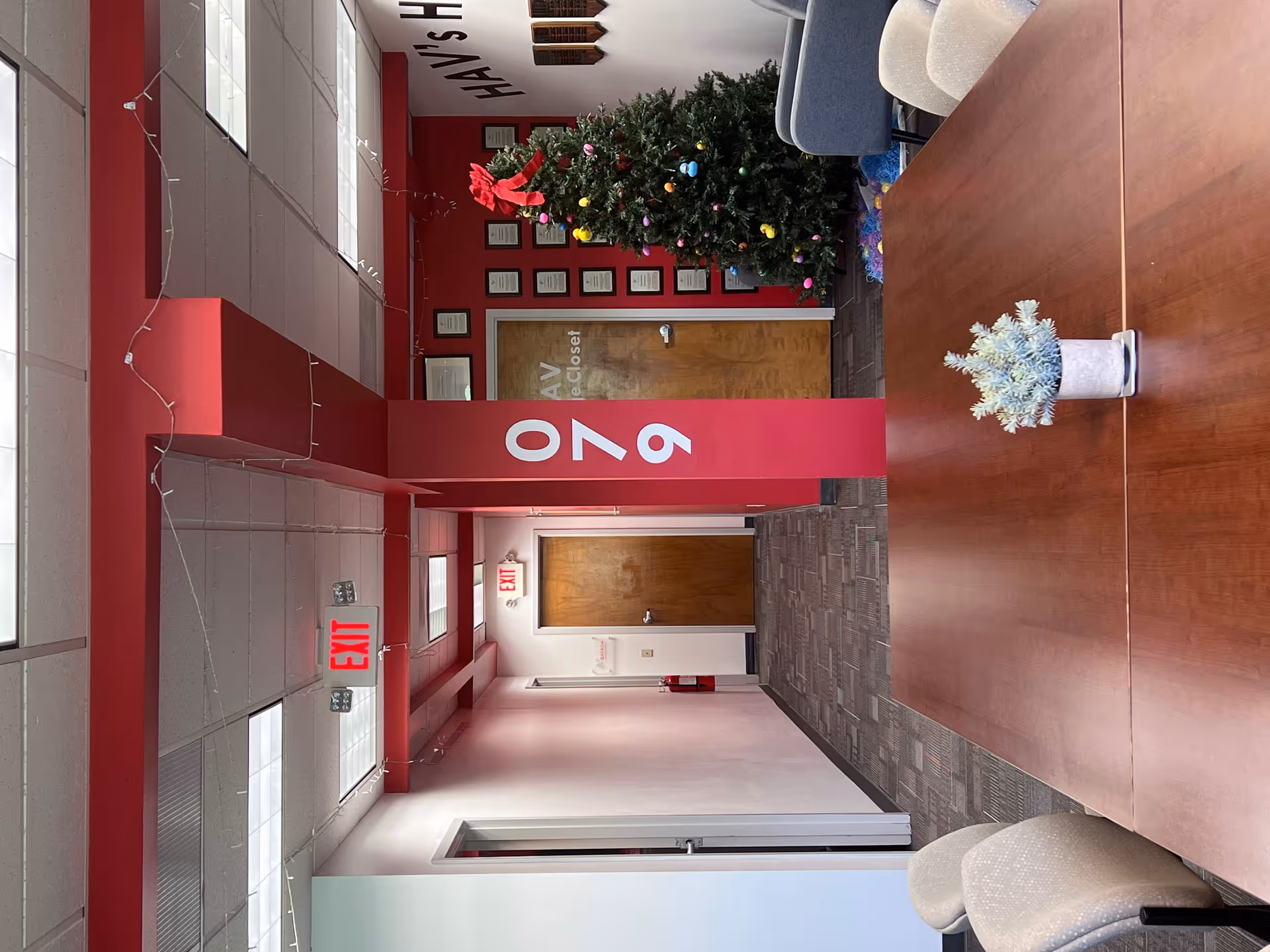 Interior corridor of BAYADA Home Health with red decor, a Christmas tree, and seating.