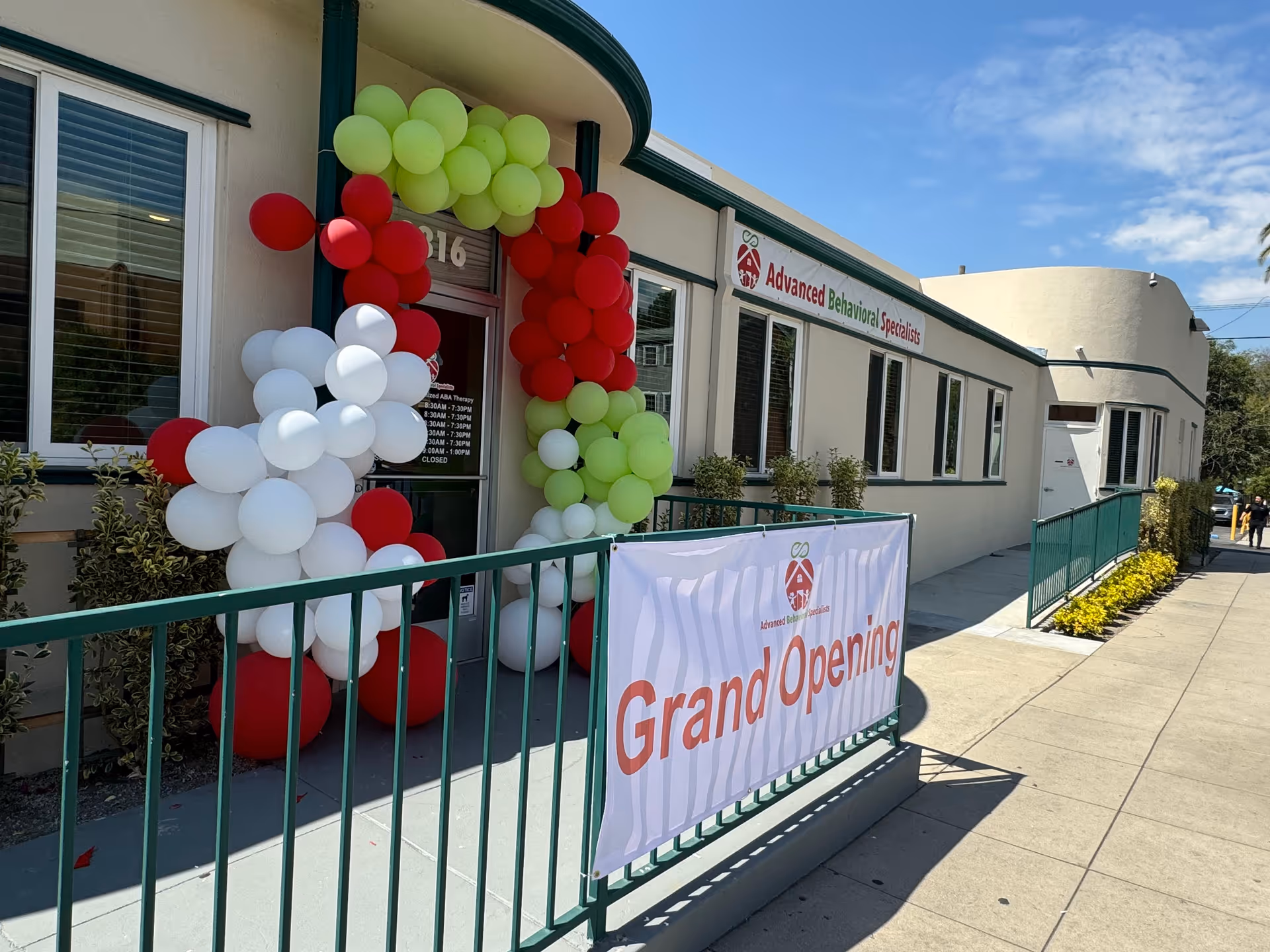 Exterior of Advanced Behavioral Specialists with a balloon arch and Grand Opening banner