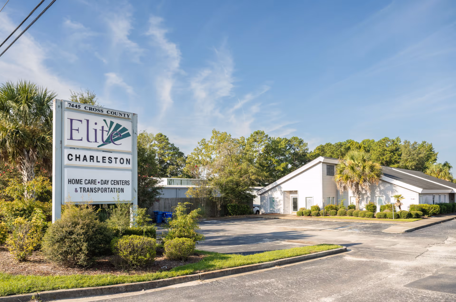 Exterior view of Elite Charleston home care facility with sign and driveway.