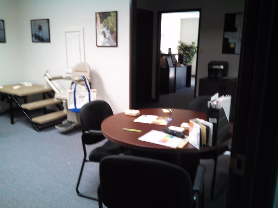 Interior office area with a round table, chairs, and brochures in a senior facility.