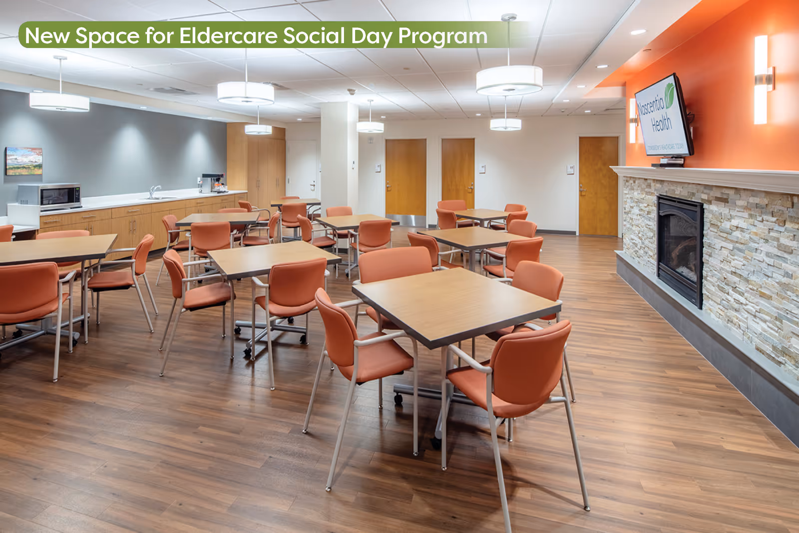 A modern communal dining area with orange chairs, wooden floors, and a stone fireplace.