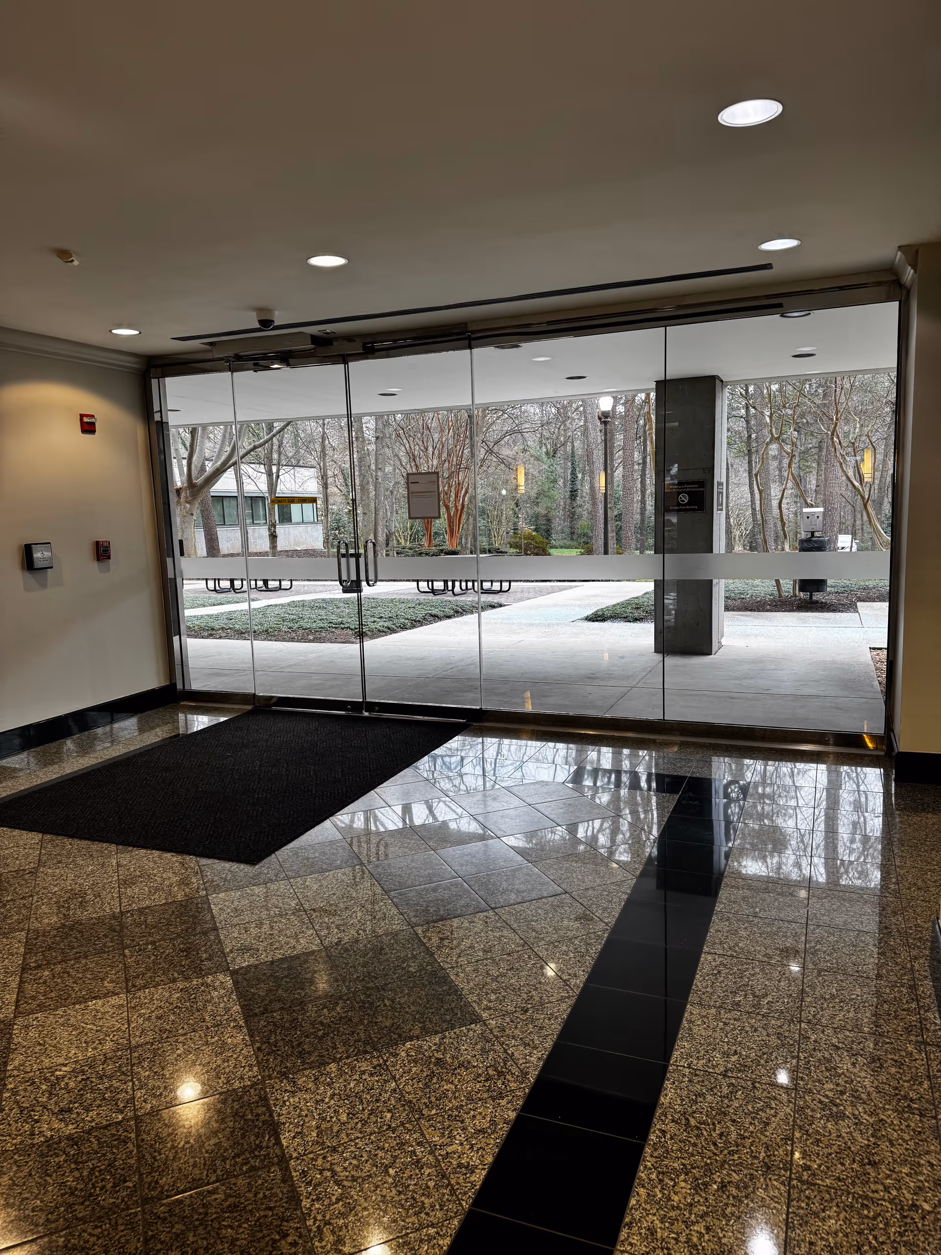 Lobby entrance with glass doors to a courtyard and outdoor benches.