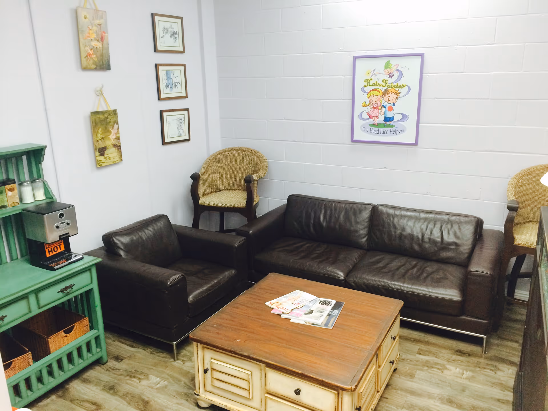 Cozy lounge area with leather sofa, chairs, coffee table, and wall art.
