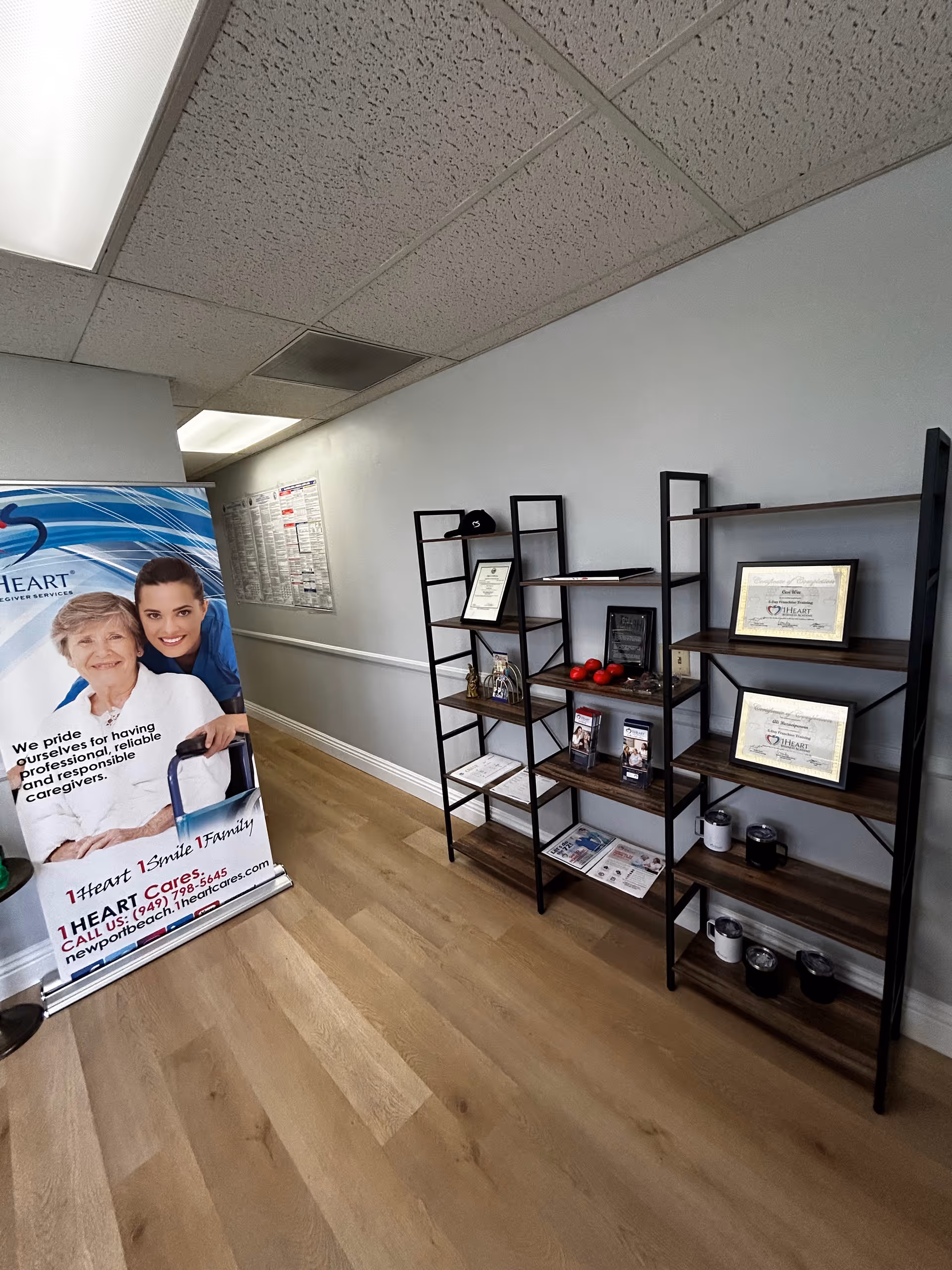 Interior hallway with a large 1Heart Caregiver Services banner and display shelves.