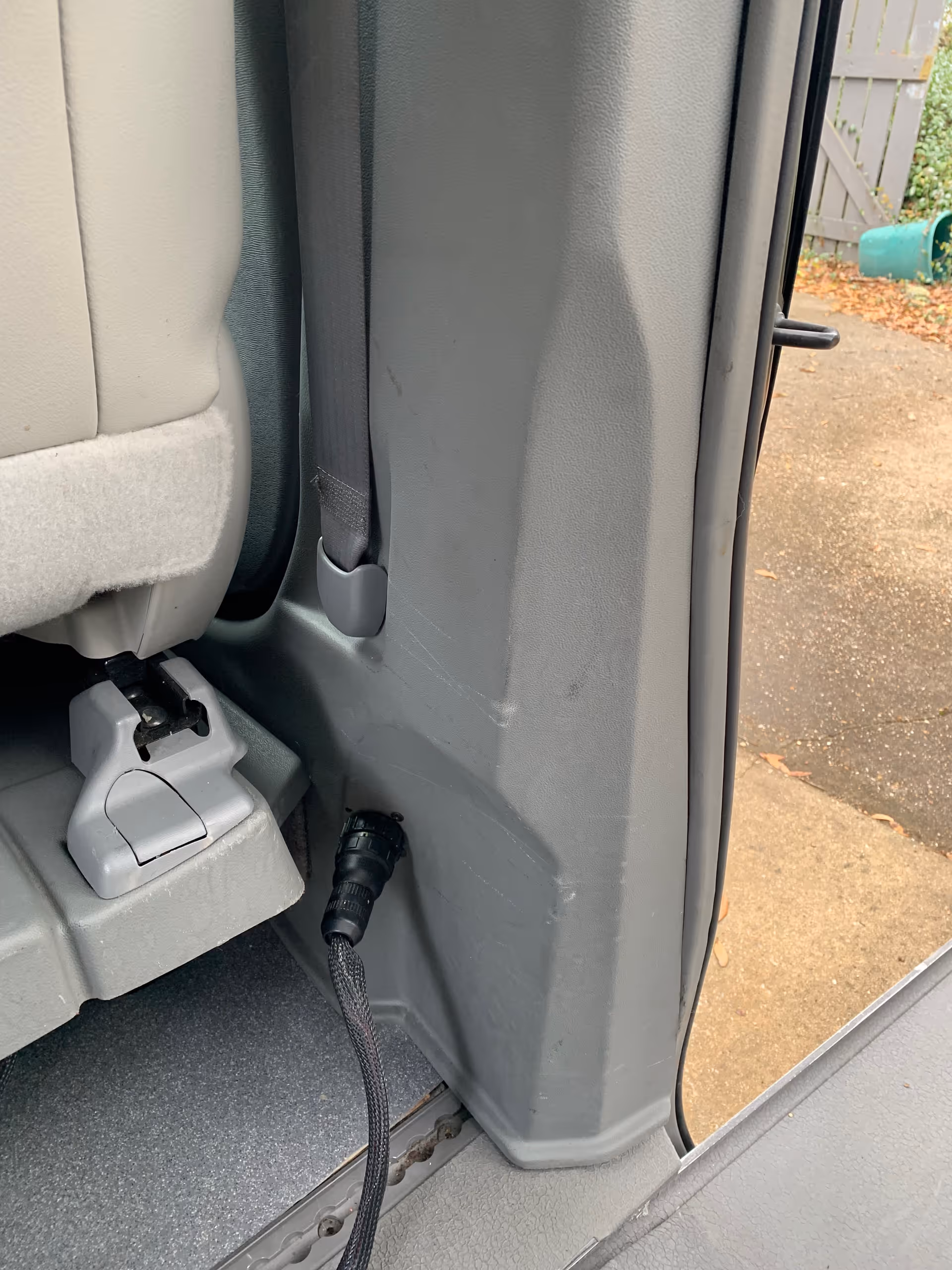 Close-up of a MobilityWorks van interior near the doorway showing a seat belt and floor panel.