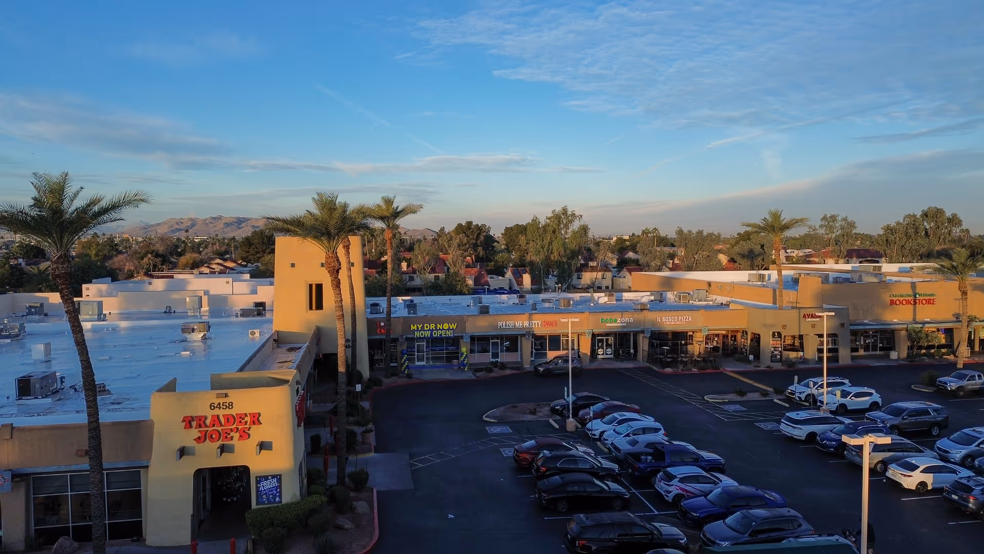 Aerial view of a strip mall with Trader Joe's and MY DR NOW storefronts and parking.