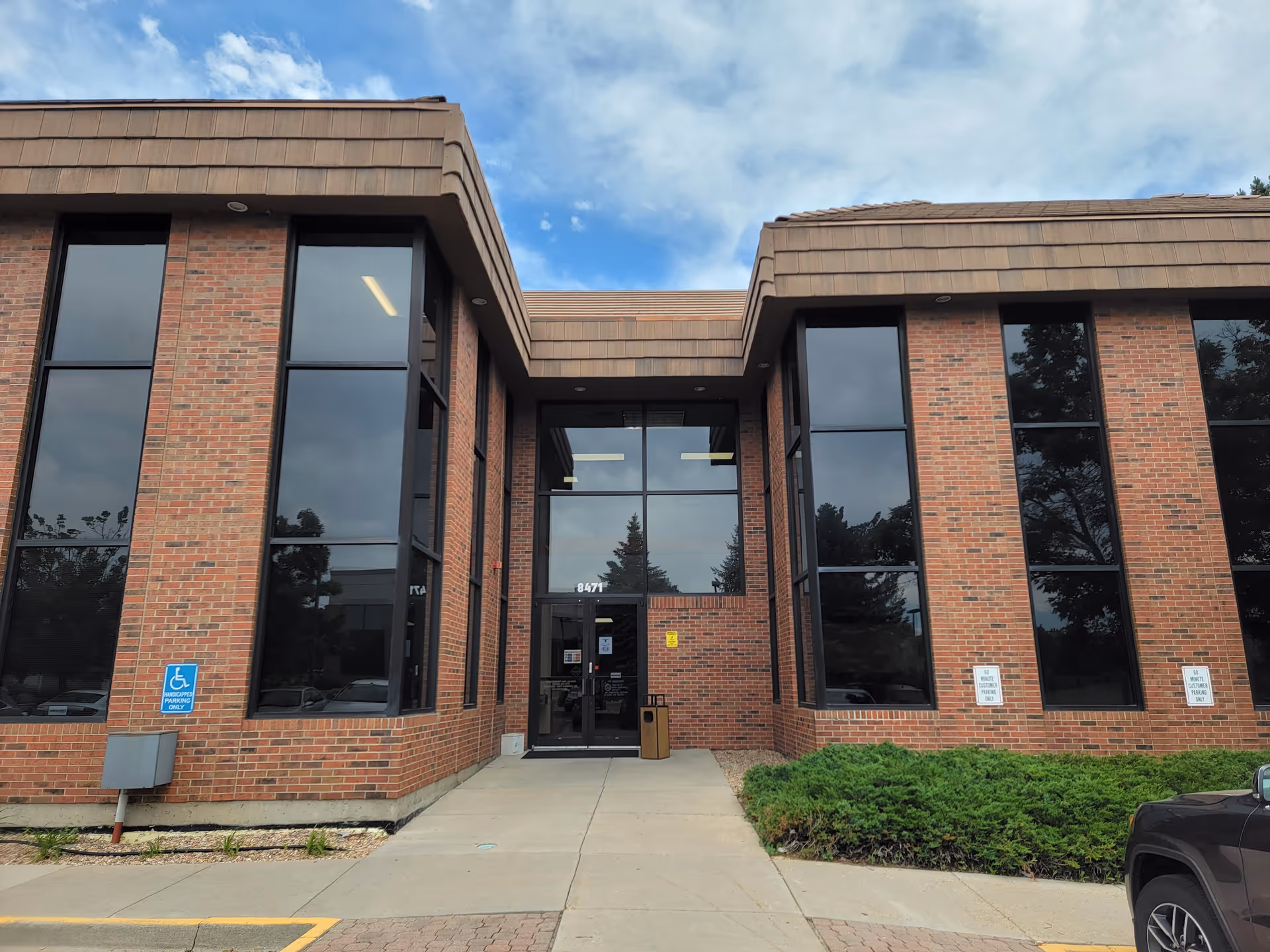 Brick exterior of HomeWell Care Services with tall windows and glass entrance.