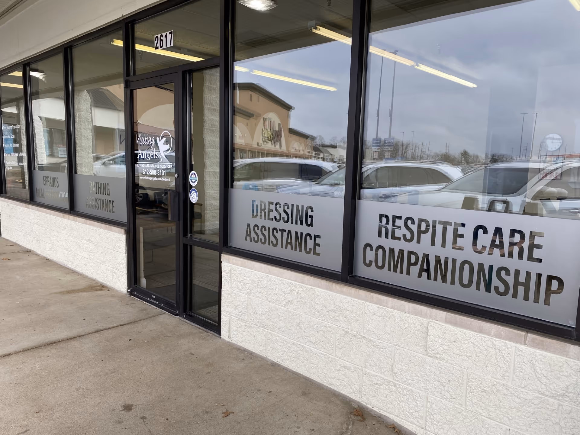 Exterior of Visiting Angels storefront with large windows displaying caregiving services.