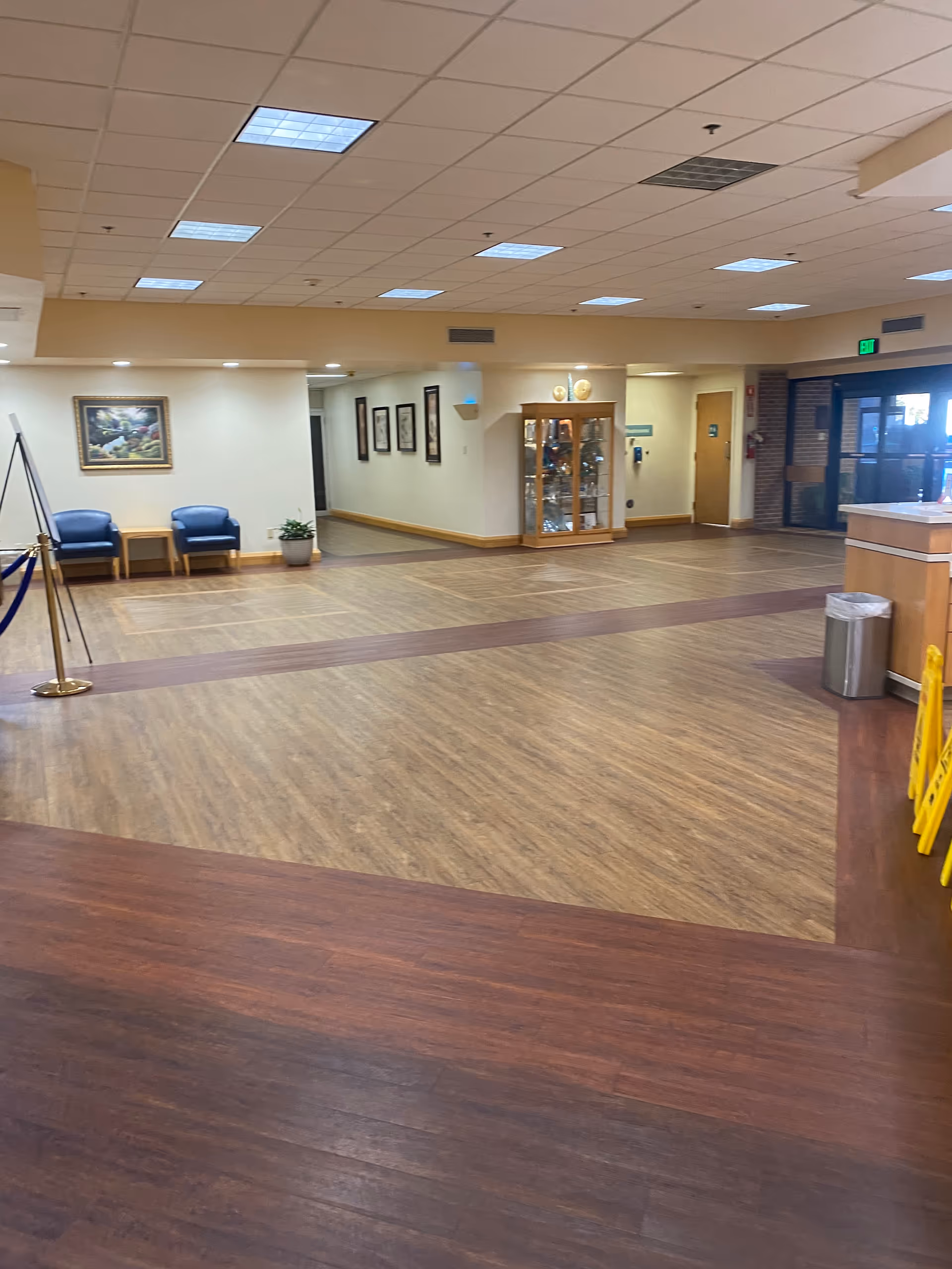 A spacious Citizens Medical Center lobby with wooden floors, seating, a glass display cabinet, and artwork.