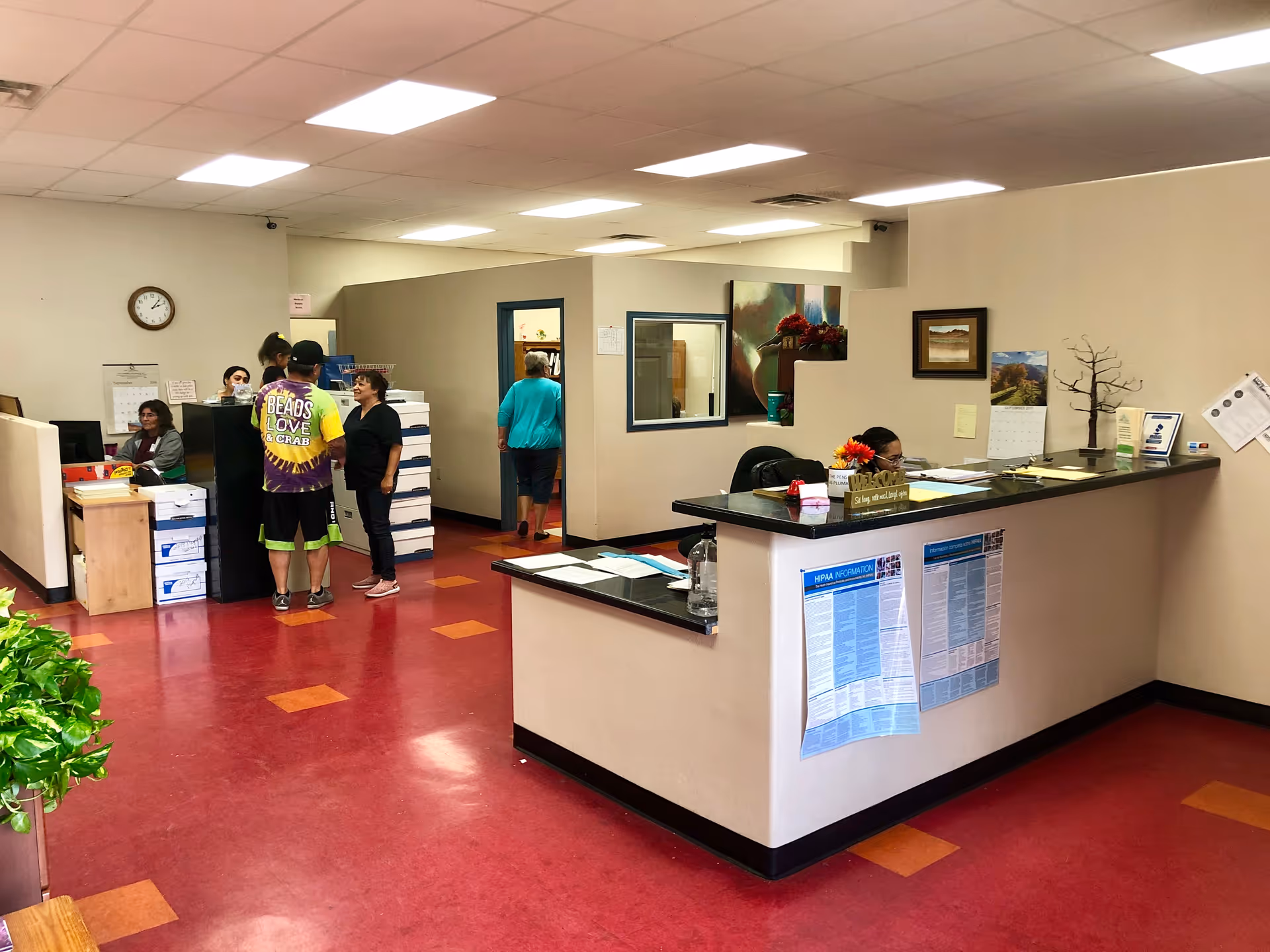 Interior reception area of a senior living facility with a front desk and staff