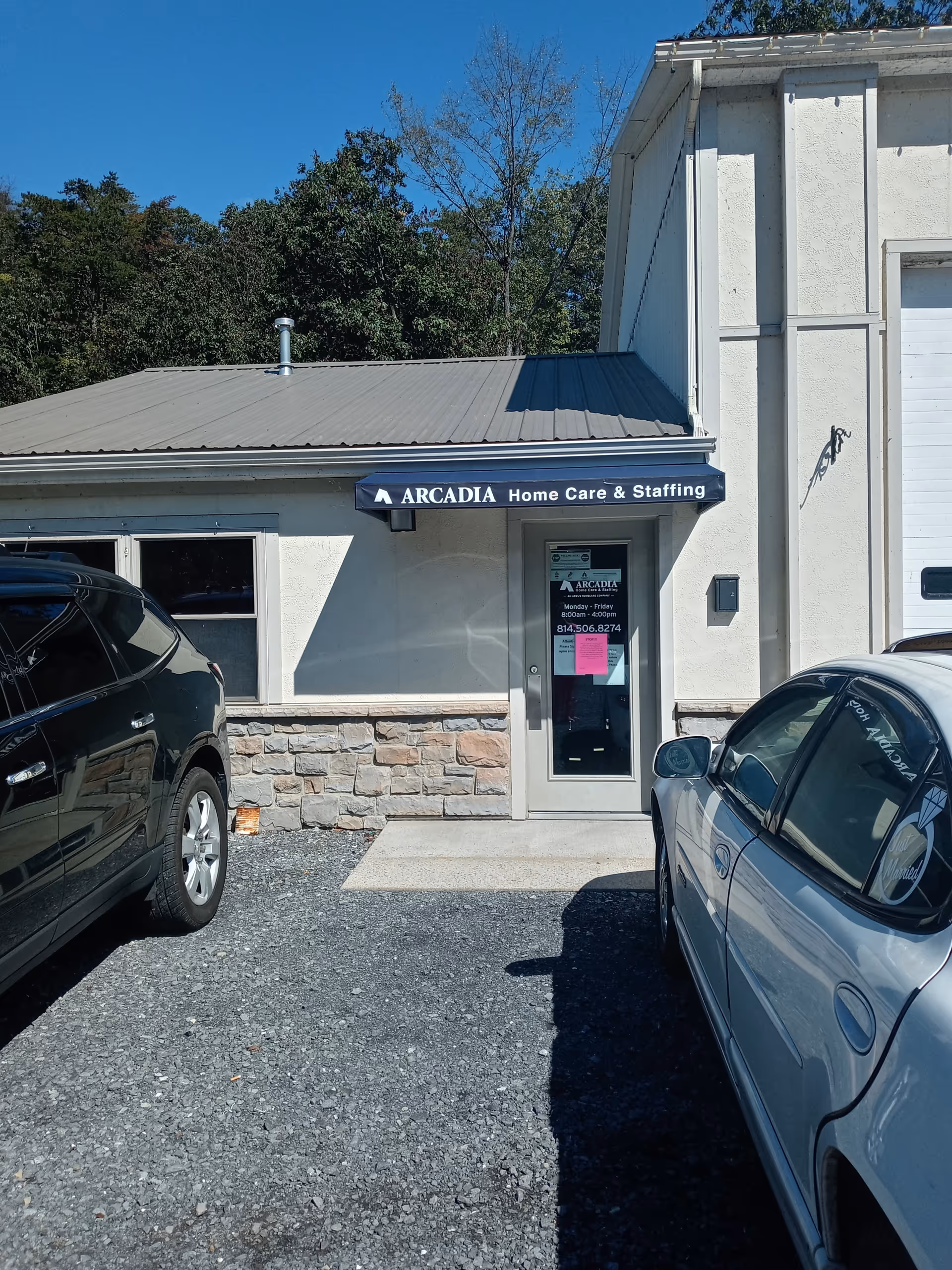 Front view of Arcadia Home Care & Staffing building with parked cars.