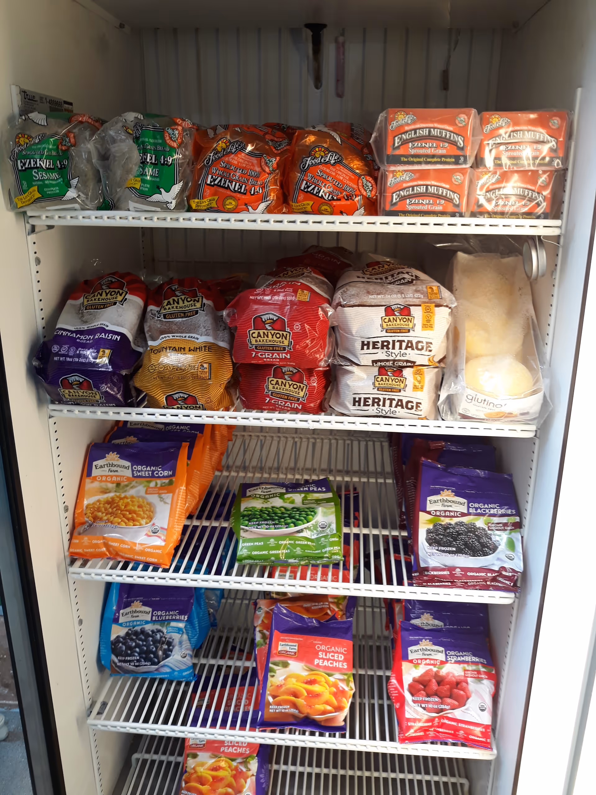 Shelves stocked with assorted packaged groceries in a pantry-like storage area of a senior facility.