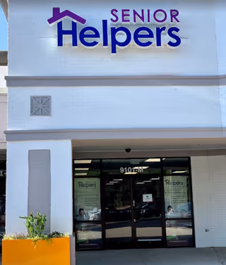 Exterior view of Senior Helpers facility entrance with large blue signage and glass doors