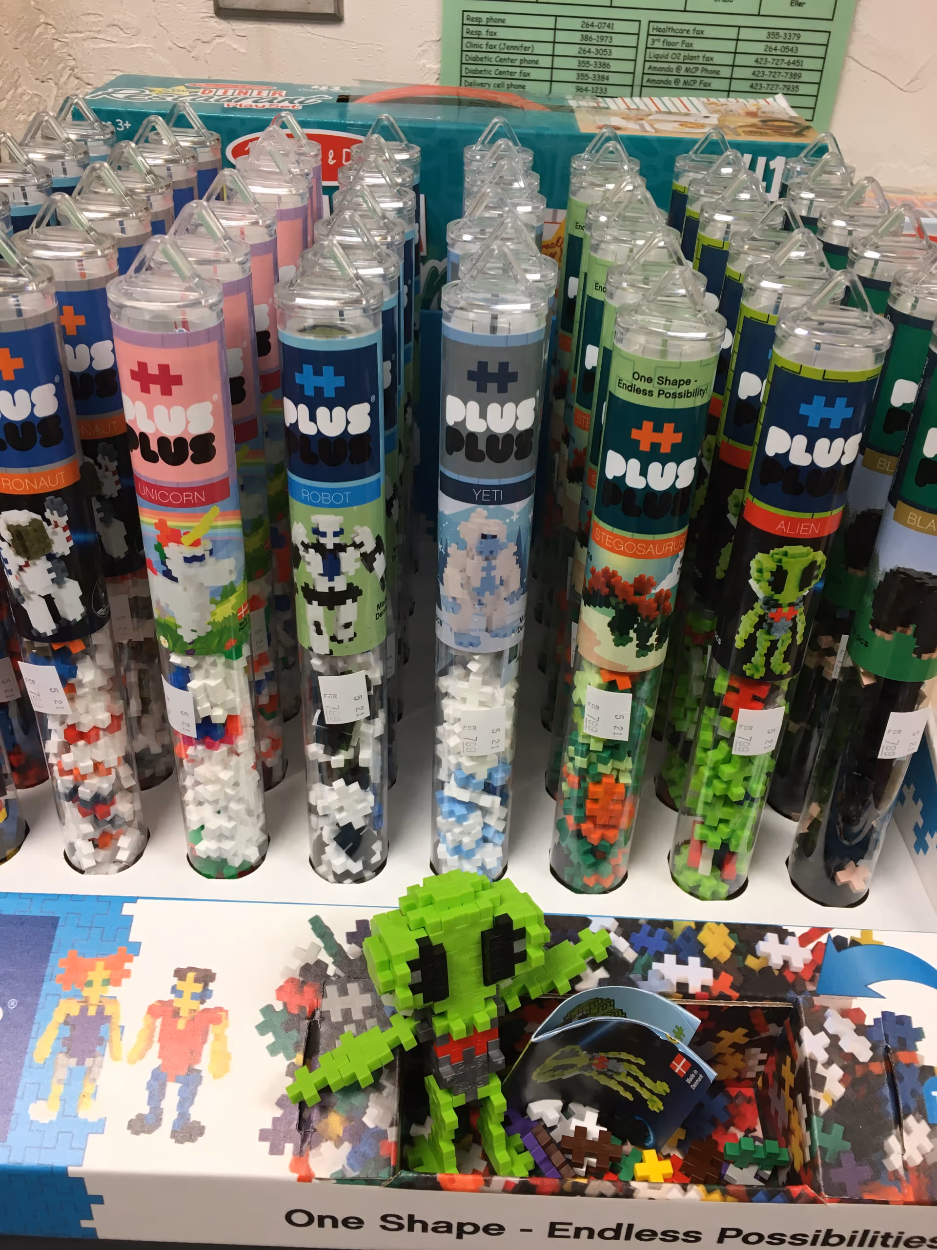 Rows of colorful Plus Plus tubes and puzzle pieces on a display table.