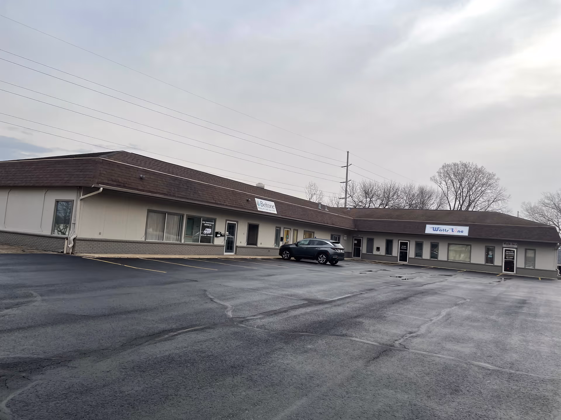 Exterior view of a single-story building with Visiting Angels signs and a parking lot.