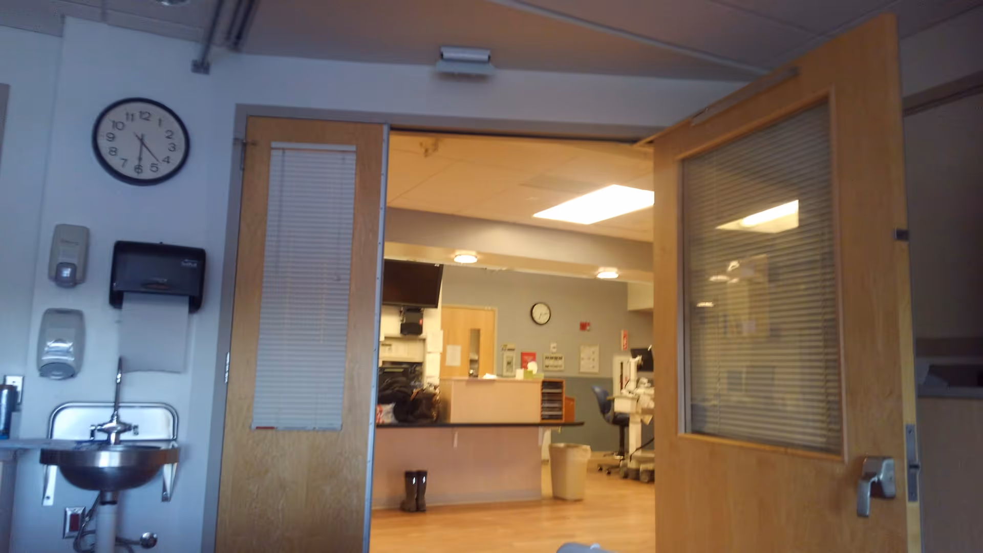 Interior of a care facility lobby with a reception desk beyond open doors.