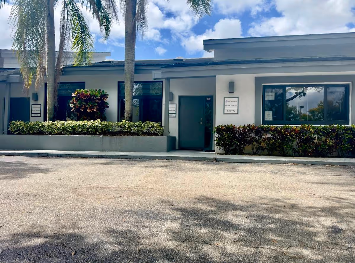 Exterior view of Nova Care Agency facility entrance with palm trees