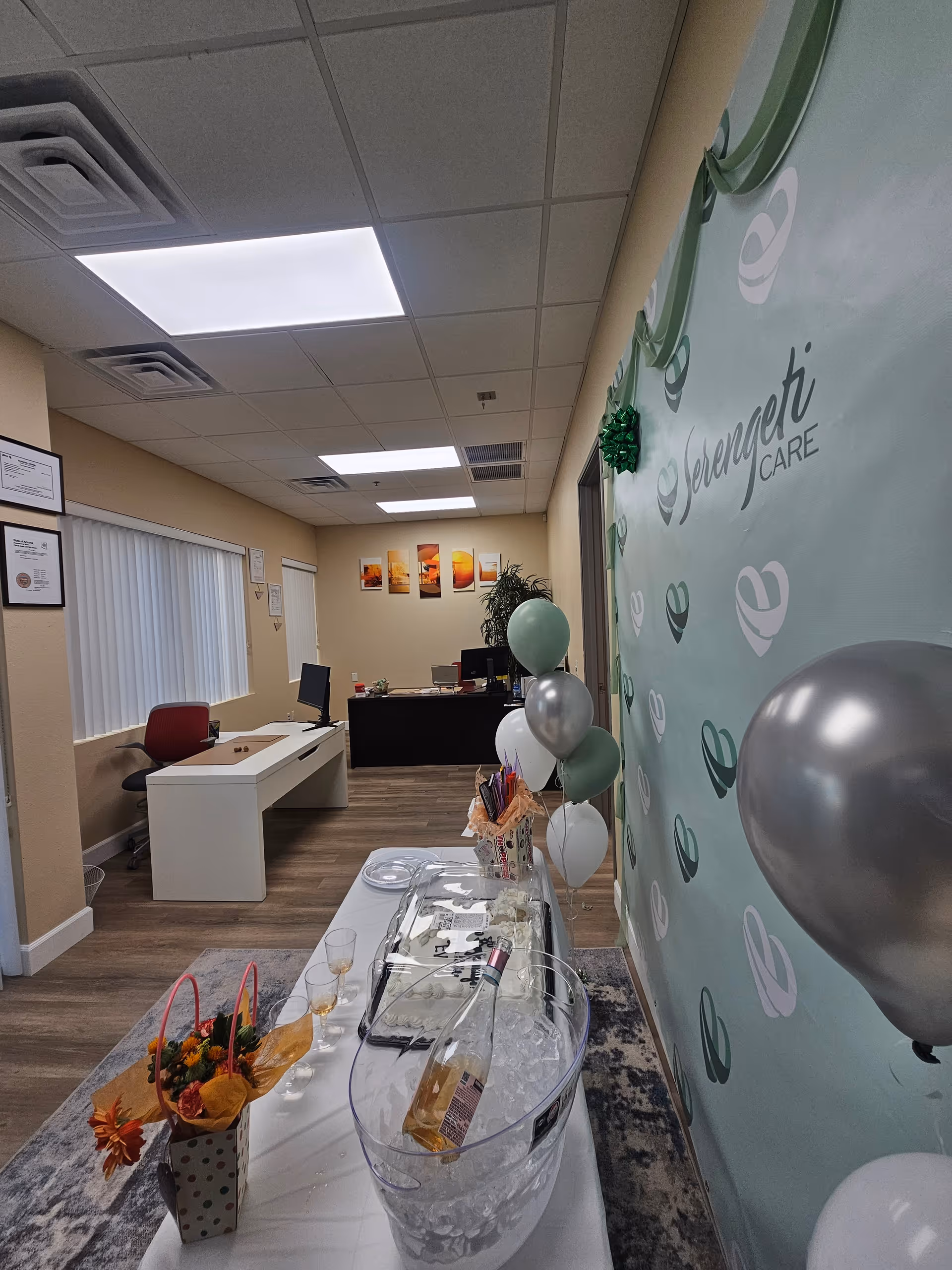 Indoor Serengeti Care reception area with balloons, a table, and celebratory setup.