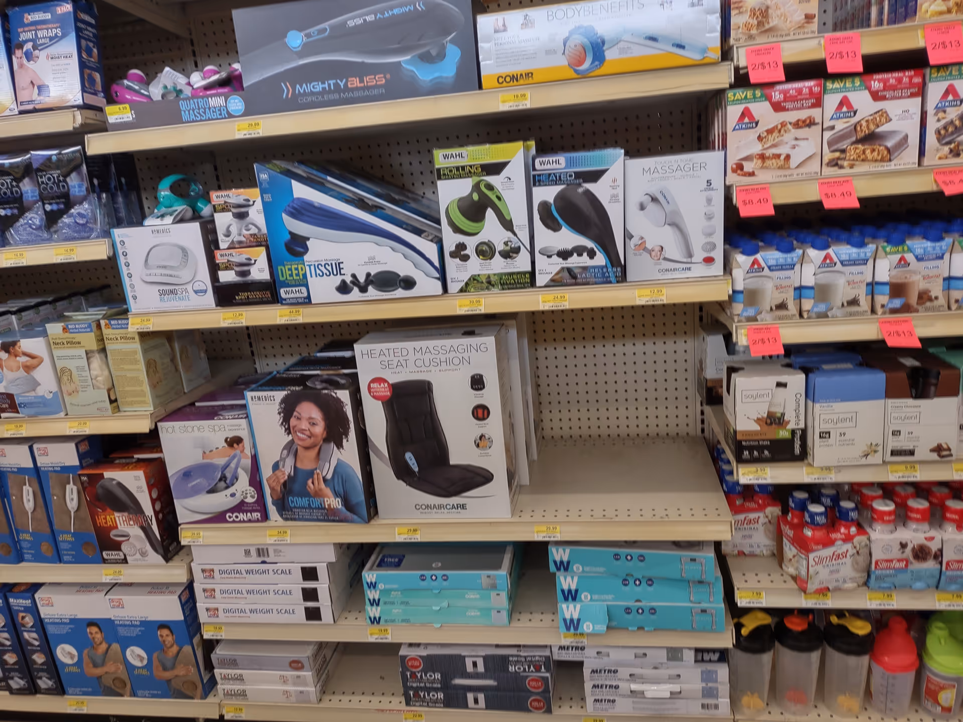 Aisle filled with boxed massagers, cushions, scales, and other health devices.
