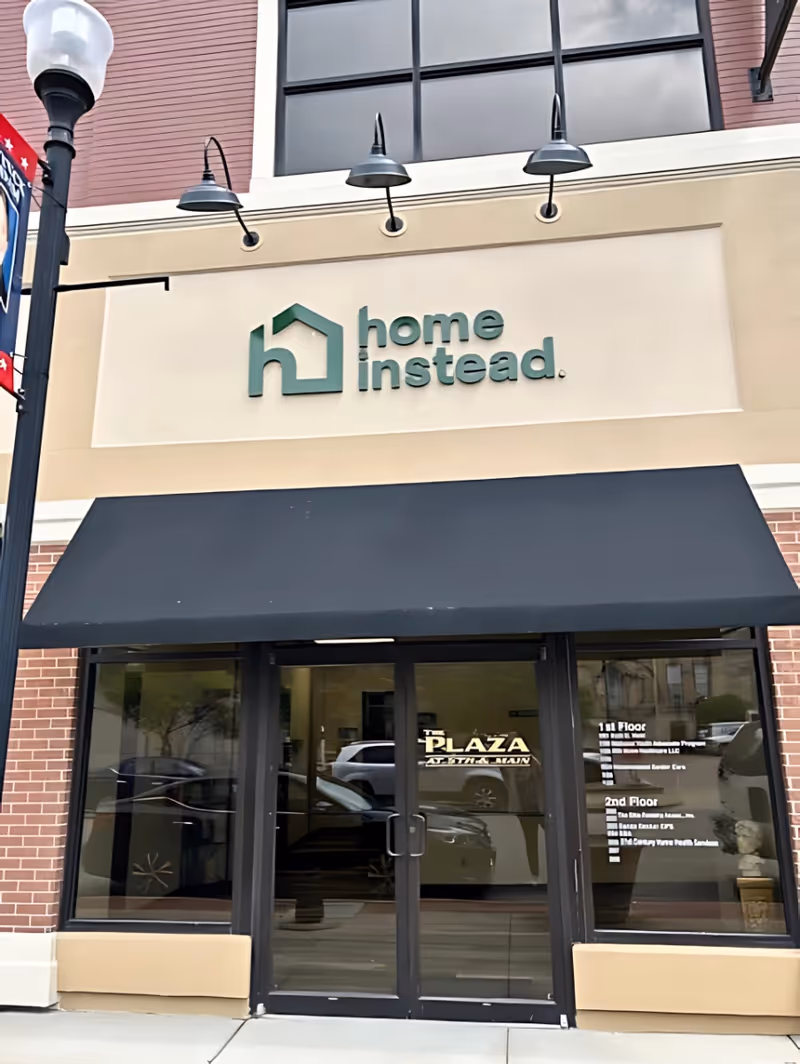 Exterior view of a building front with Home Instead sign and entrance.