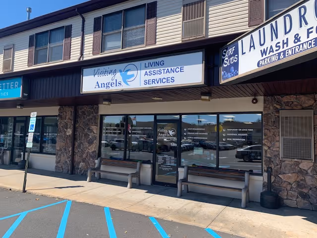 Exterior of Visiting Angels Senior Home Care storefront with signage and benches.