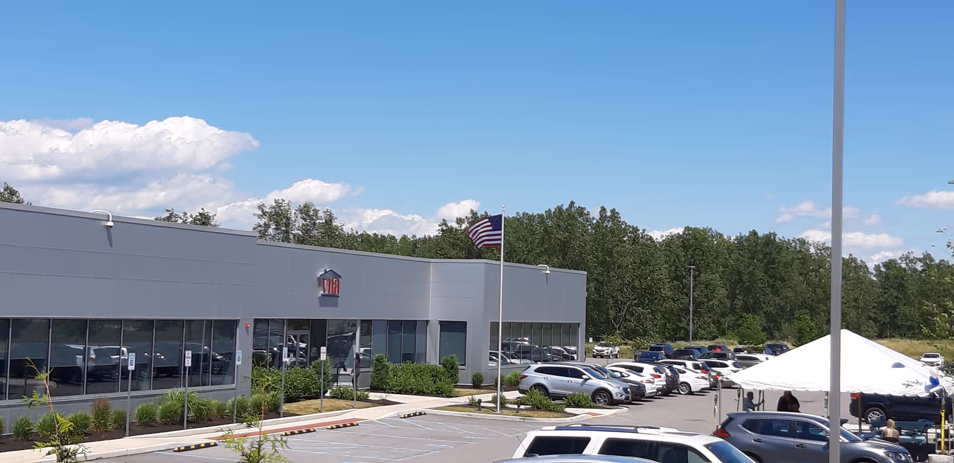 Exterior view of the VNA of WNY senior facility with parking lot and flag.