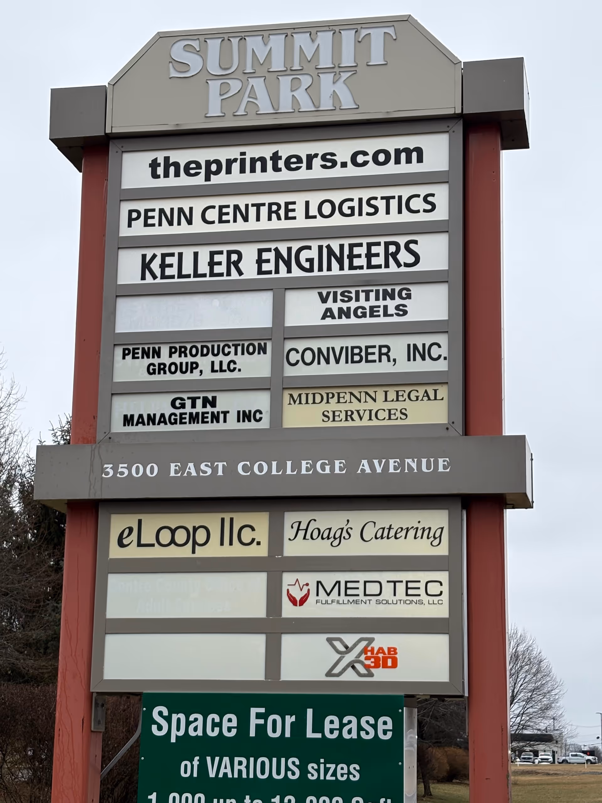 Tall outdoor signboard listing tenants at Summit Park, including Visiting Angels.
