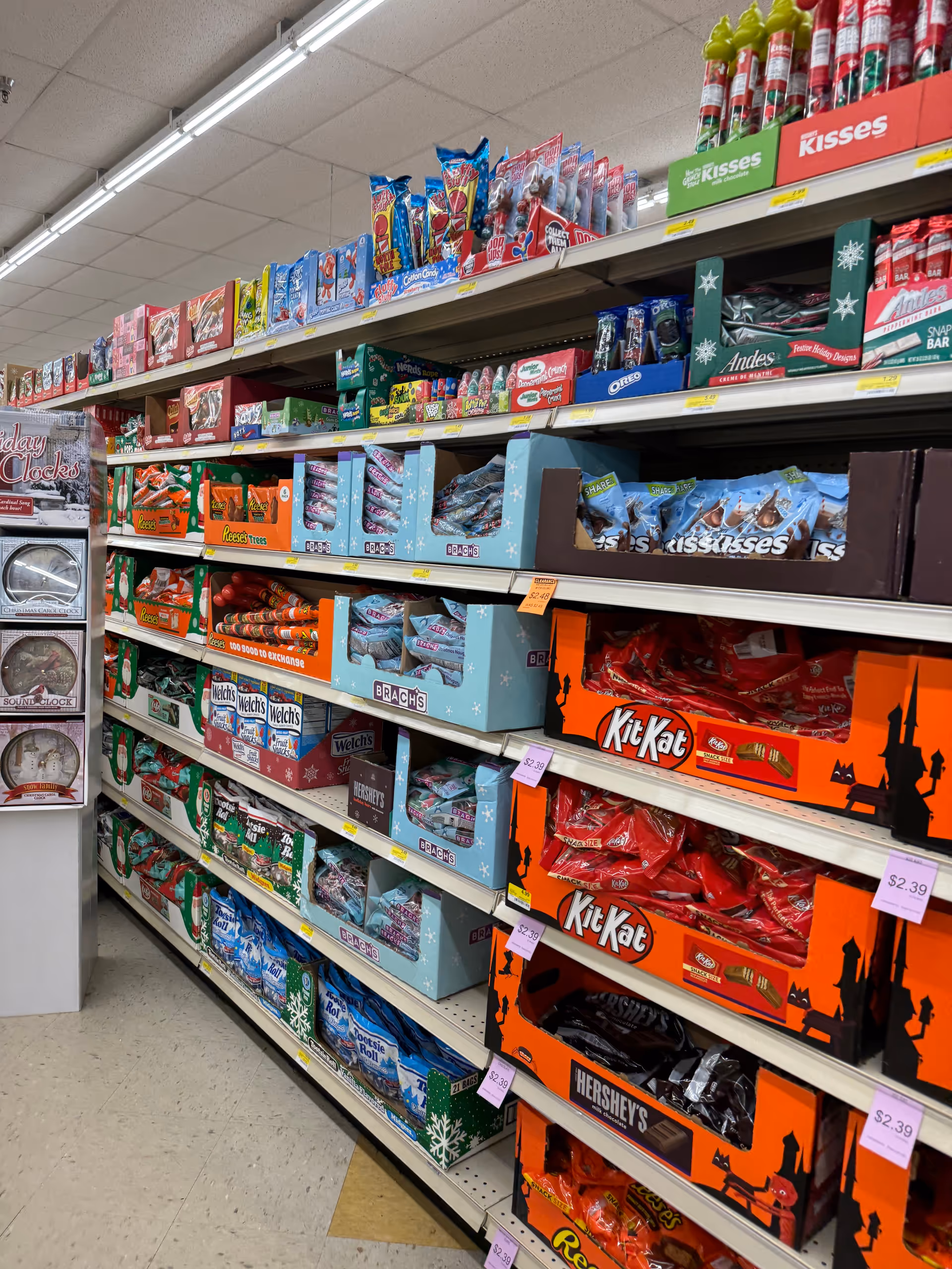 An interior store aisle filled with candy boxes and assorted snack displays.