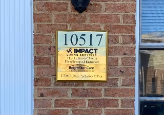 Brick exterior wall with a BrightStar Care sign beside a blue door and window.