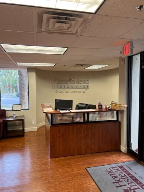 Reception area with front desk, computer, and Home Instead Senior Care sign.