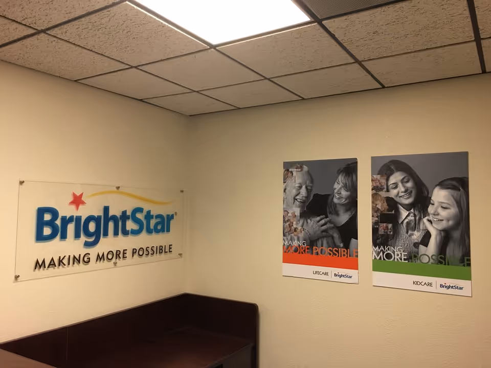 Corner of BrightStar Care interior with a large sign and two posters on wall.