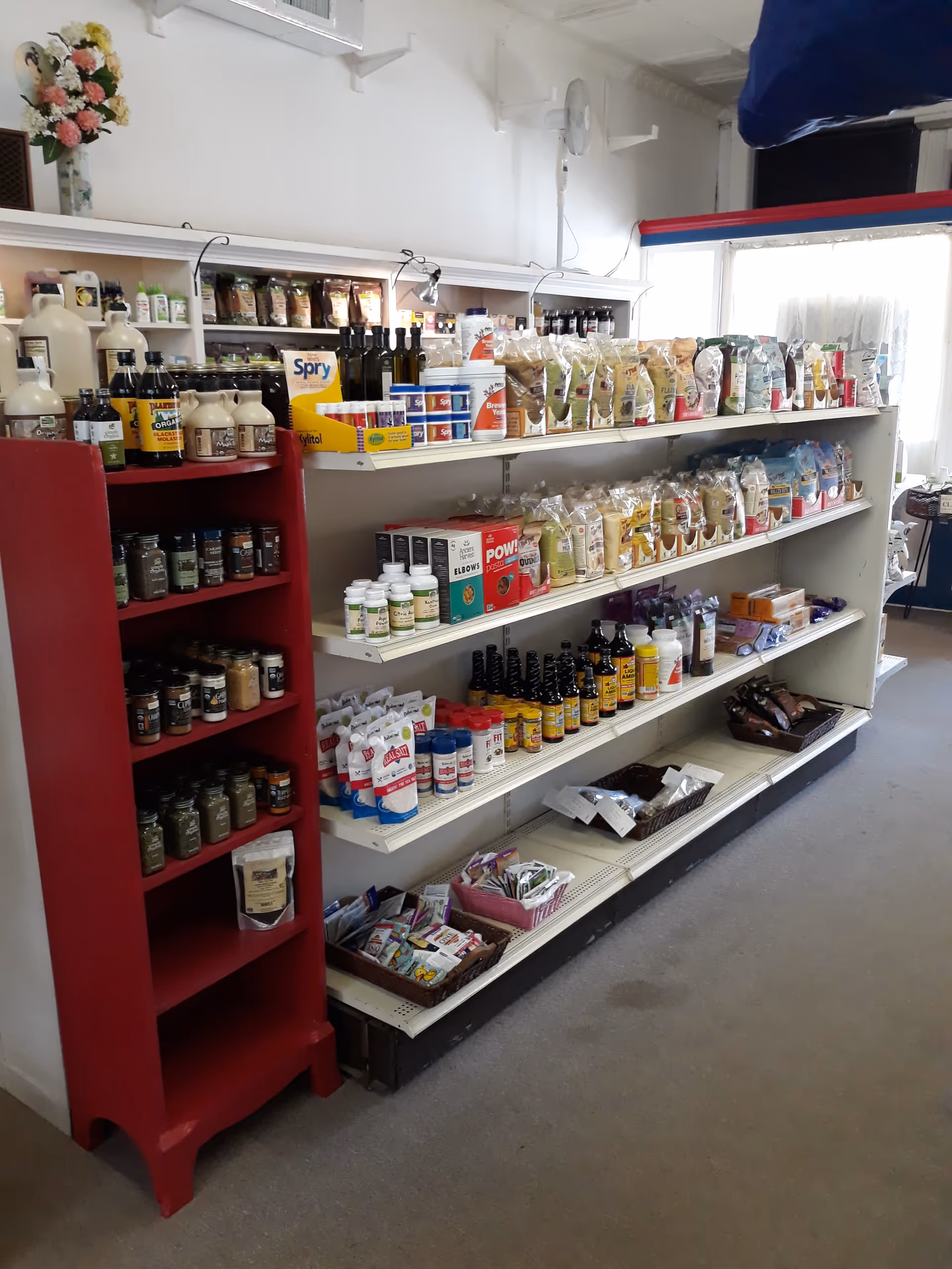 Shelves stocked with bottles and bags of supplies inside a senior living facility store.