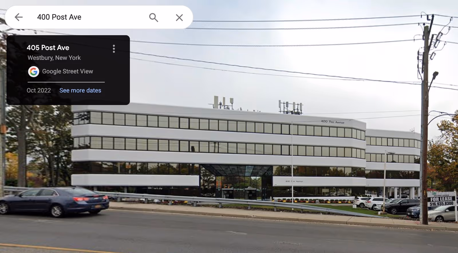Modern multi-story building with large windows along a street, no people visible