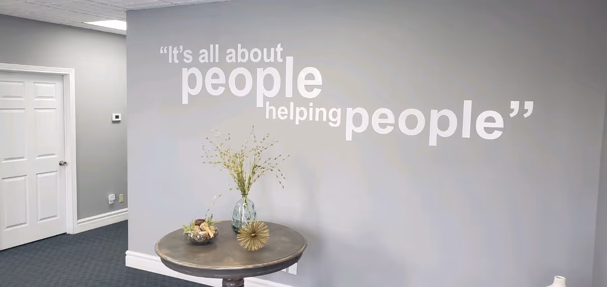 Interior wall featuring a large quote and a round table with decor.