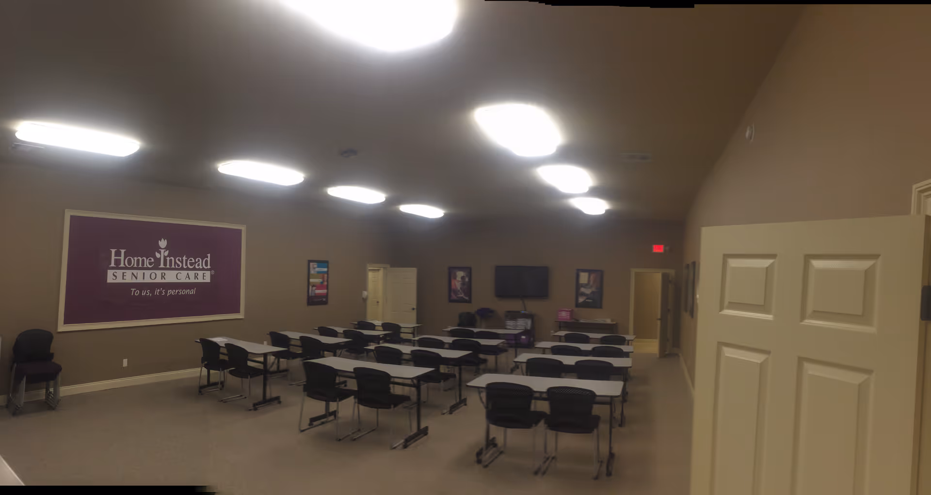 A large training room at Home Instead with rows of tables and chairs.