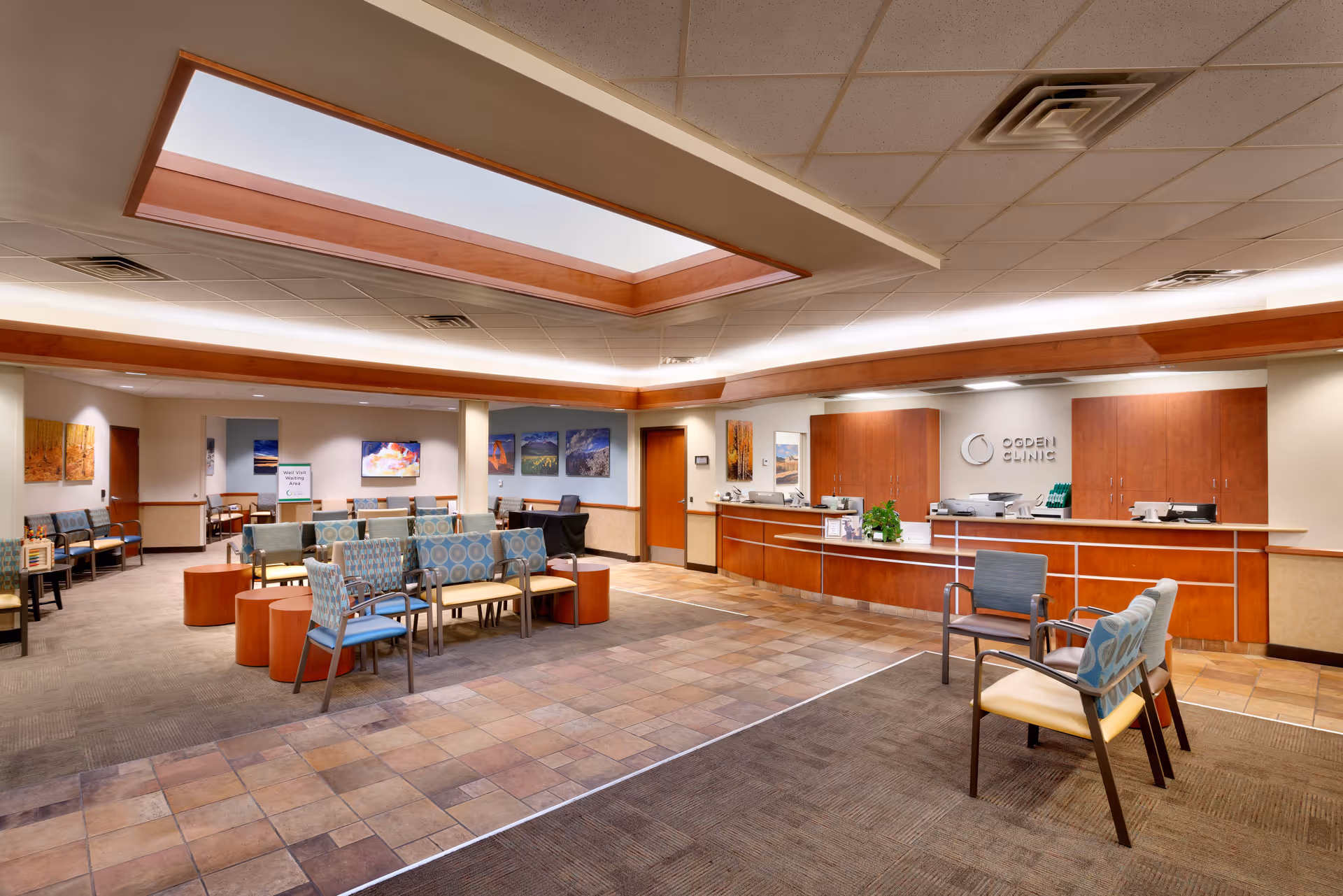 Spacious interior lobby with a reception desk, seating areas, and skylight