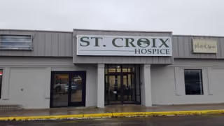 Front exterior of St. Croix Hospice building with entrance doors and signage.