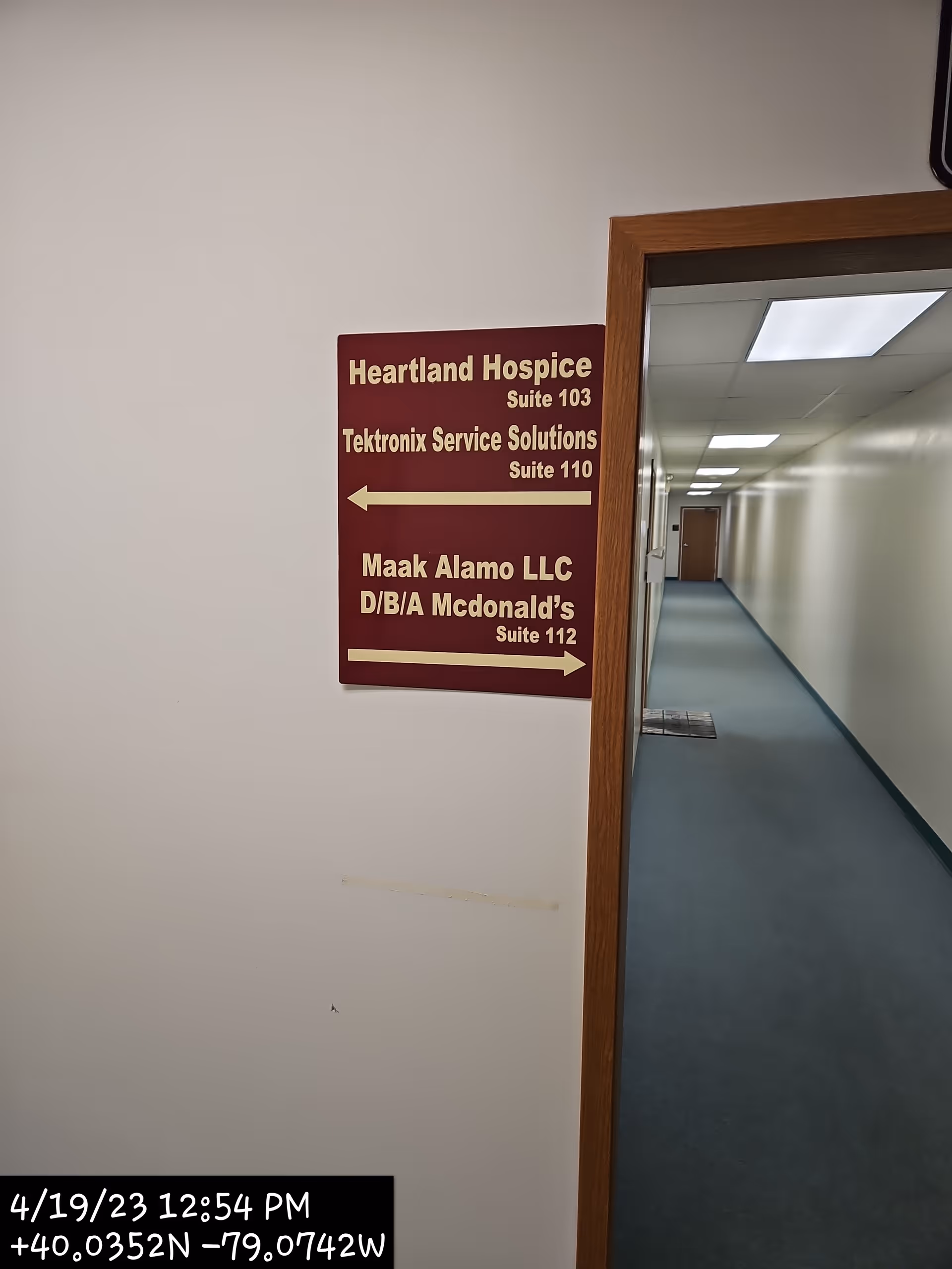 Heartland Hospice sign on wall beside a long interior hallway.