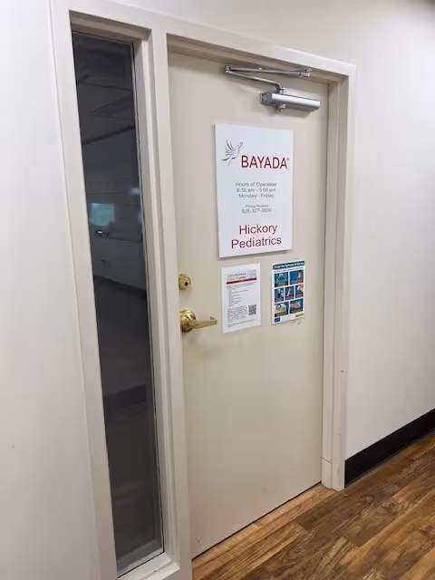 Interior hallway door with BAYADA Pediatrics sign and attached notices