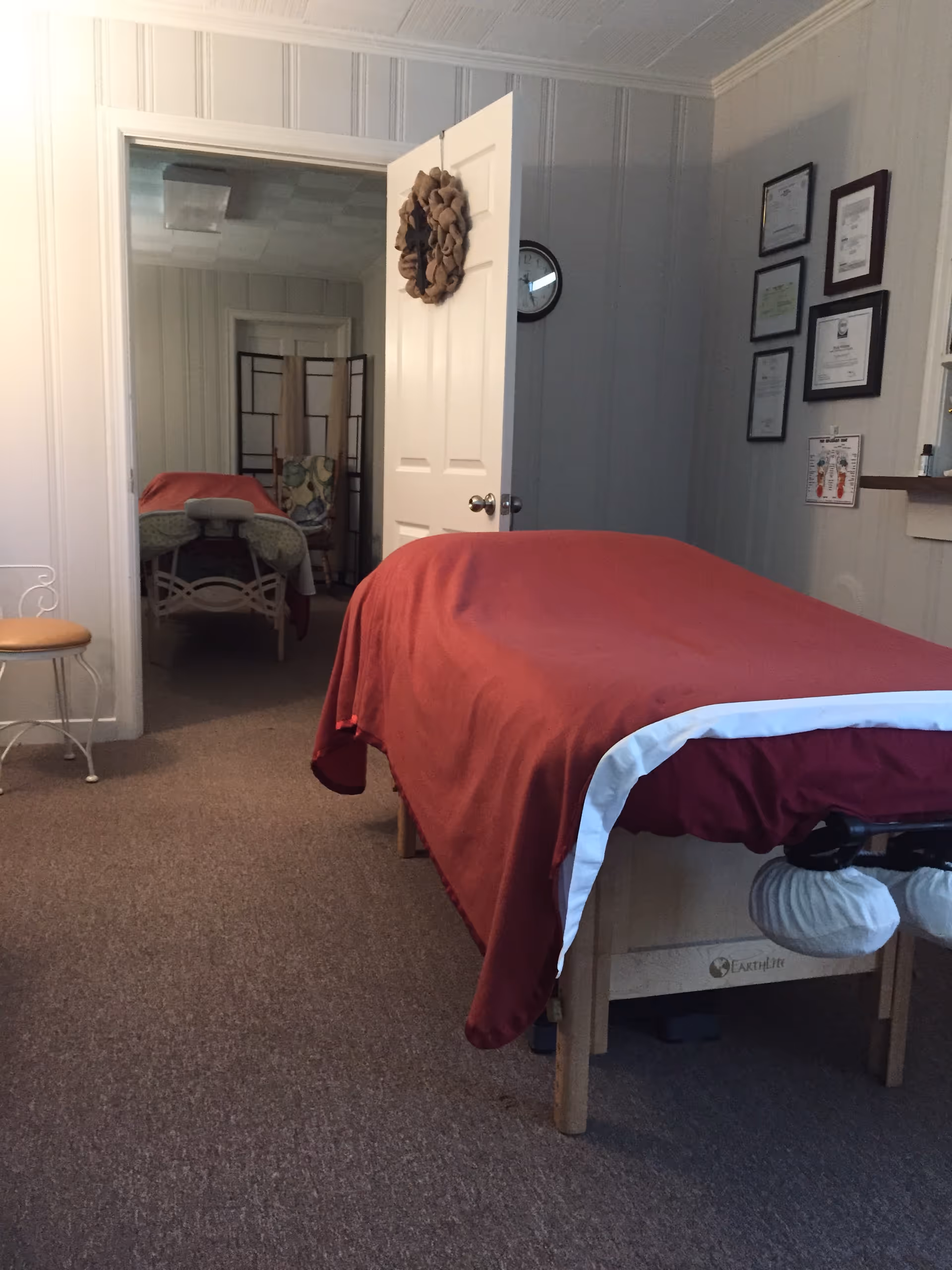 Two beds with red blankets in a cozy treatment room of a senior living facility.